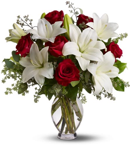 Teleflora's Baby Be Mine - TFWEB629 - The look of love plus the scent of love. What woman could resist the heavenly fragrance of lilies along with the beauty of passionately red roses? Silly question. The fragrant bouquet includes white Asiatic lilies and red roses accented with fresh greenery delivered in a classic clear glass vase. Bouquet is approximately 19” W X 20 1/2” H. This item is hand-arranged and delivered by a florist. Orientation: All-Around As Shown : TFWEB629