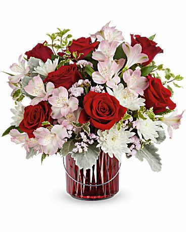 Garden Glow Bouquet - Illuminate your space with our Garden Glow bouquet, showcasing vibrant red and soft pink blooms in a striking red glass lantern with a silver handle. This captivating arrangement brings a cozy warmth to any setting! This arrangement features red roses, pink alstroemeria, white cushion spray chrysanthemums, pink sinuata statice, dusty miller, leatherleaf fern, and pitta negra. Delivered in Teleflora's Merry Glow Lantern, this bouquet also serves as a charming votive or decorative piece. Orientation: All-Around