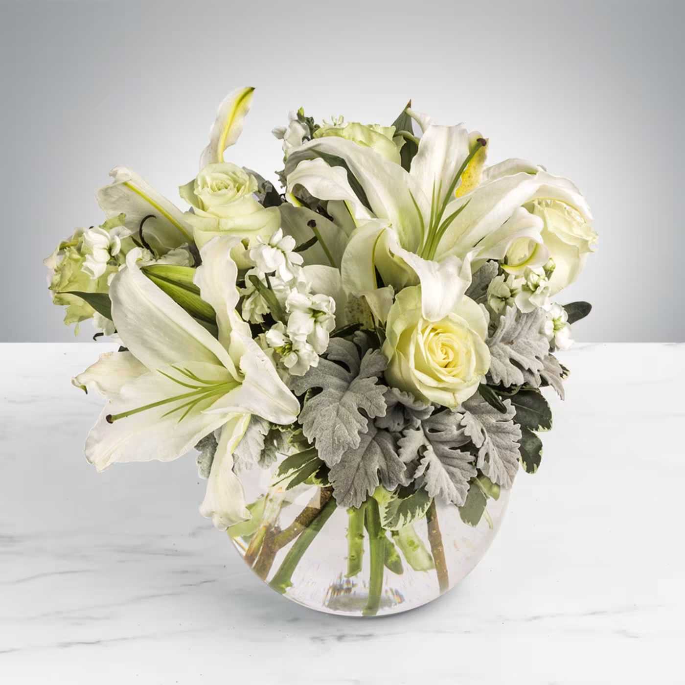 Sweet Thoughts by BloomNation™ - This arrangement includes white roses, white asiatic lilies, white stock, and dusty miller. Send your condolences with Sweet Thoughts by BloomNation™.   APPROXIMATE DIMENSIONS:10&quot; H X 11&quot; W X 11&quot;L