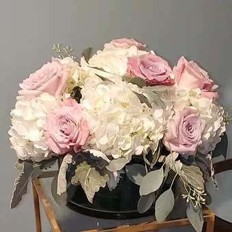Unrivaled Beauty - Premium white hydrangea, dusty miller and georgeous pink roses in a beautiful 8 inch cylinder.