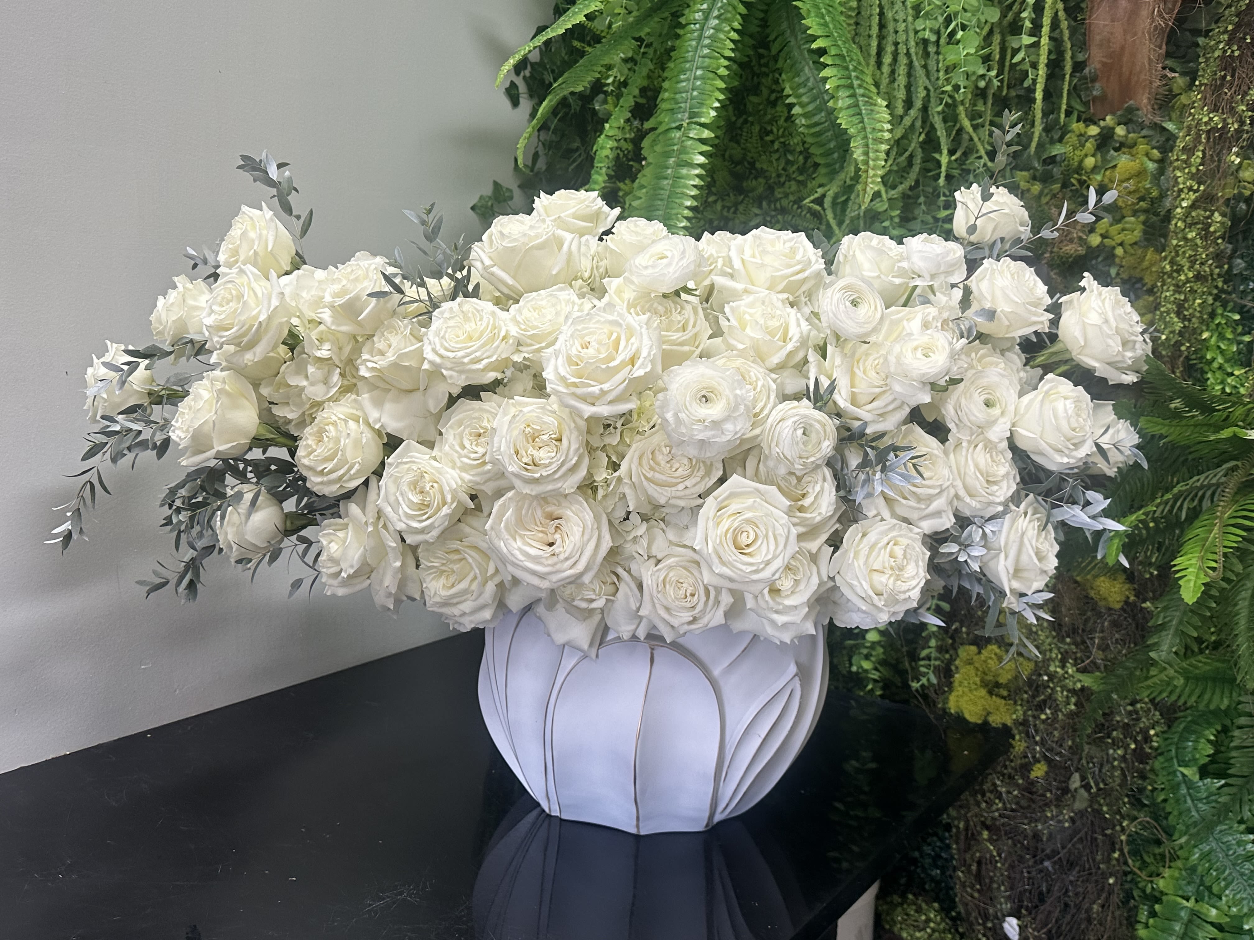 White Fancy White Fancy - White Roses gorgeous design, asymmetric composition. Full and lush with white blooms, white elegant roses in all directions and accents of with white ranunculus rested in modern stunning round vase. Some florals are seasonal, if particular flower will not be available due to season, we will substitute for similar flower, composition, color pallet and value of the arrangements as closely as possible. All effort to create a floral arrangement as close to the photo shown, the actual arrangement may vary slightly in its appearance from the photo shown. If you have any questions about your order, we welcome you to call us in or email