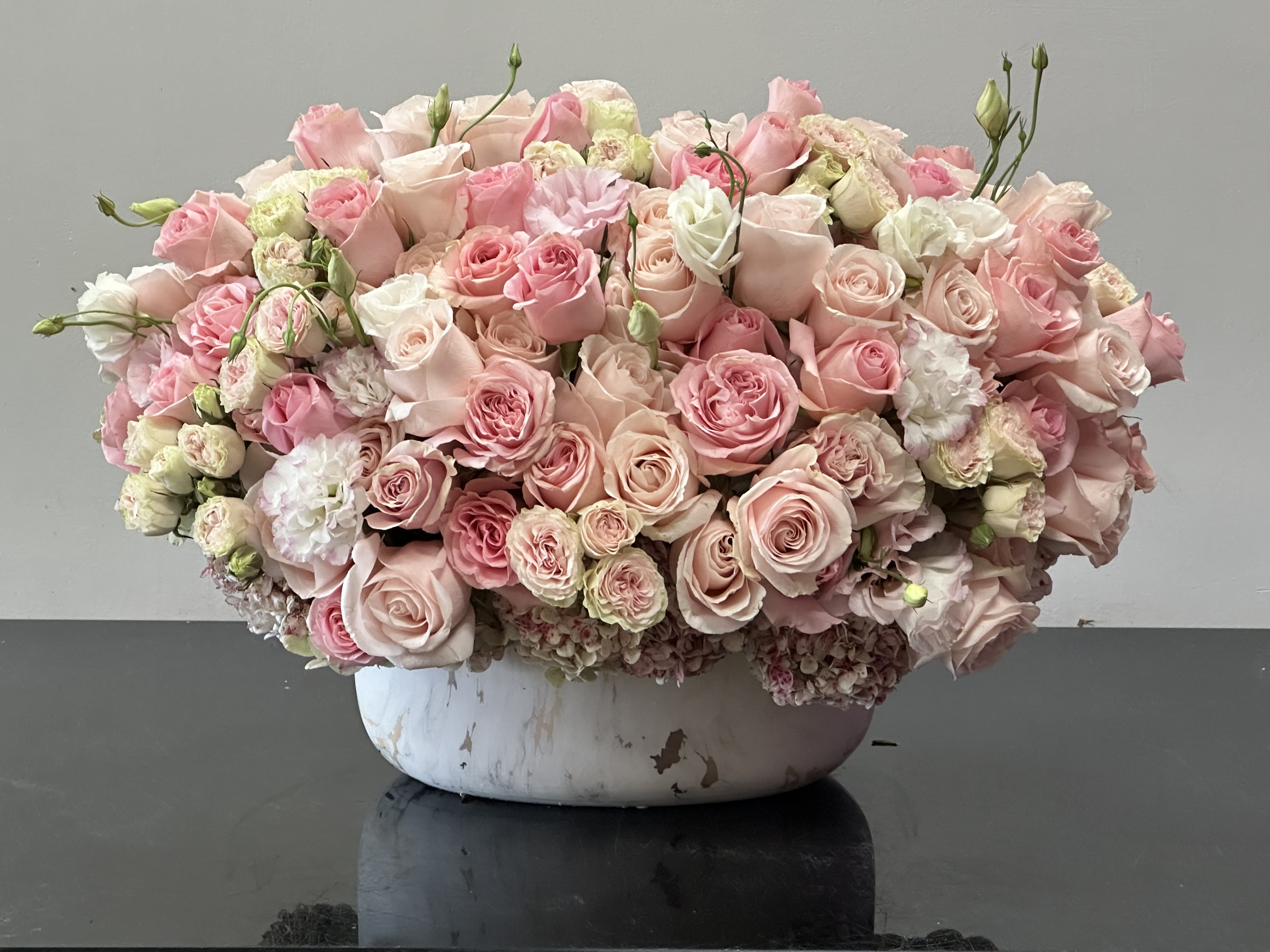 Peaches and Cream Peaches and Cream - This stunning floral design is the perfect hues of pastels of peach and pinks. Filled with a pillow of roses and accents of ivory whites is the perfect element to brighten up any setting. Resting inside a vintage white vase is truly a lovely display of sweet emotions. Some florals are seasonal, if particular flower will not be available due to season, we will substitute for similar flower, composition, color pallet and value of the arrangements as closely as possible. All effort to create a floral arrangement as close to the photo shown, the actual arrangement may vary slightly in its appearance from the photo shown. If you have any questions about your order, we welcome you to call us in or email