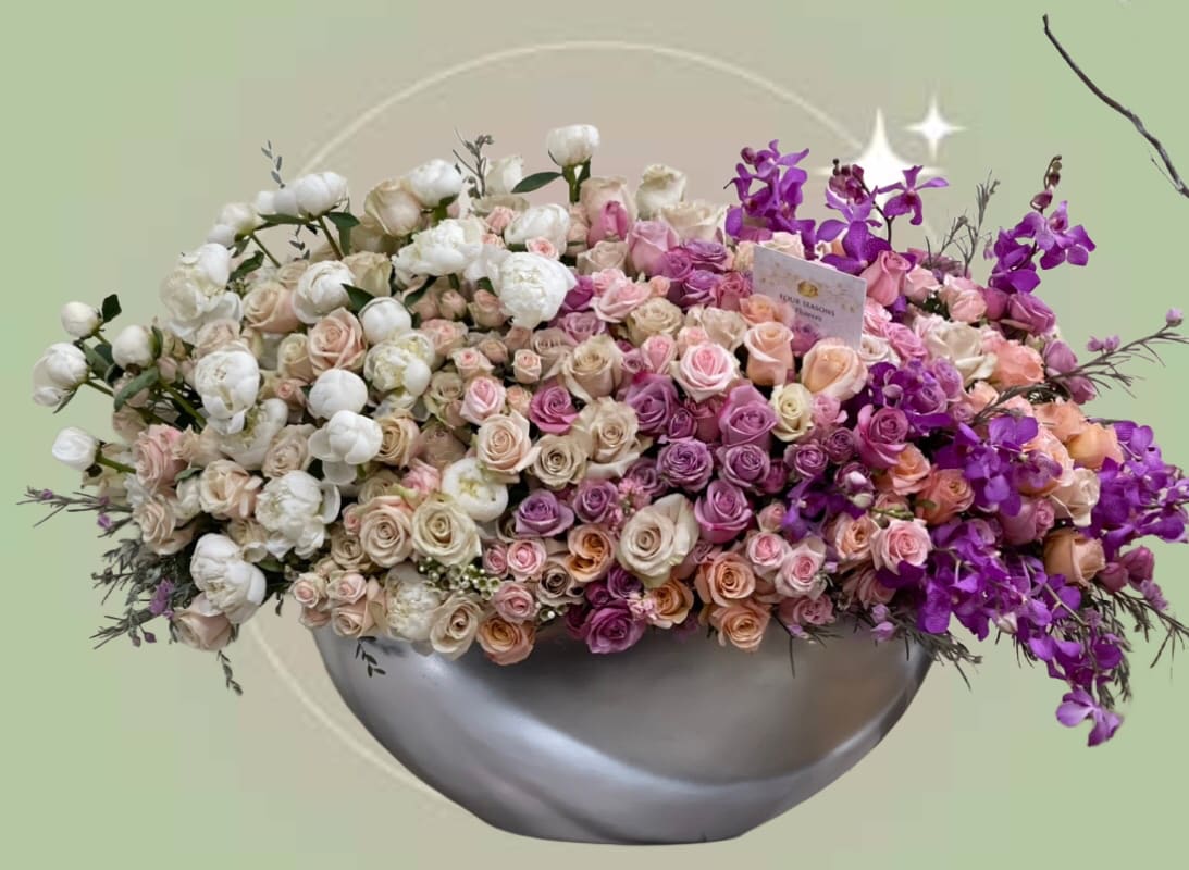 Bloom Boom Bloom Boom - This magnificent and luxurious harmonious fusion of mix of the perfect symphony of florals creating bloom boom. With an array of garden roses, spray roses, peonies and premium cut orchids with touches of greenery is lush and luxurious making an impressive statement This stunning arrangement rests in 21-inch ceramic vase, overall, 50 inch in width with composition Some florals are seasonal, if particular flower will not be available due to season, we will substitute for similar flower, composition, color pallet and value of the arrangements as closely as possible. All effort to create a floral arrangement as close to the photo shown, the actual arrangement may vary slightly in its appearance from the photo shown. If you have any questions about your order, we welcome you to call us in or email