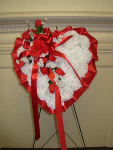SILK BLEEDING HEART -MEDIUM NEW-04 SILK BLEEDING HEART -MEDIUM NEW-04 - Our MEDIUM SILK BLEEDING HEAT is made of quality SILK-PERMANENT white carnations and red roses flowing down the center with red ribbon bow and comes on a tall easel stand.. The heart is 20" wide and 24" tall and stands 50" tall on the easel. OUR SILK AND PERMANENT SYMPATHY FLOWERS are an economical alternative to live fresh flowers and are also great for those LAST MINUTE FUNERAL ORDERS when there is not enough time to create fresh flower sympathy designs.. MOST ALL of our local cemeteries allow silk and permanent flowers to remain on the grave for quite some months and are a very practical option during the freezing winter months or the extremely hot summer months in our area.