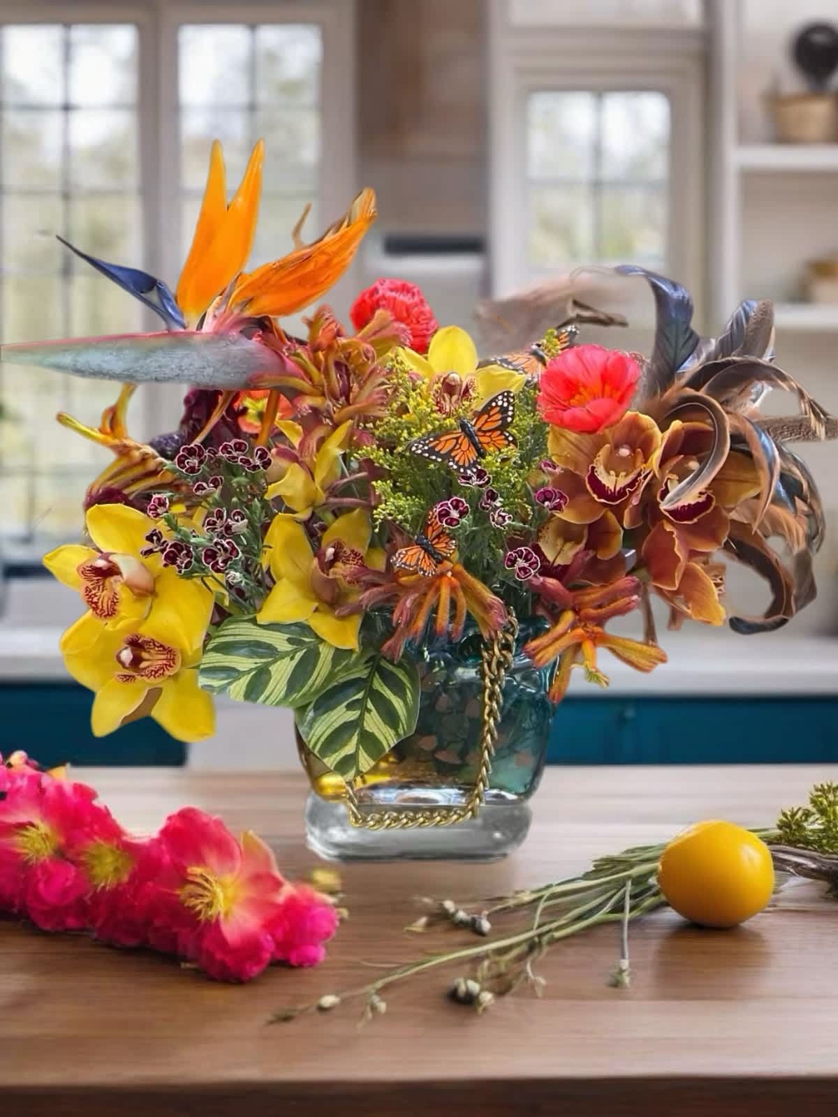 Tropical fusion in paradise  - Discover the allure of tropical florals with our stunning arrangement featuring vibrant birds of paradise and delicate orchids. The centerpiece is beautifully showcased in our signature club purse-shaped vase, made in Murano island, Italy, adding an elegant touch to any space. At Vespera, we pride ourselves on our unique and stylish designs, and this arrangement is no exception. Bring a touch of exotic beauty into your home or office with this eye-catching floral masterpiece. Send these flowers to someone special today ! We deliver flowers! Boss Day is coming up !  