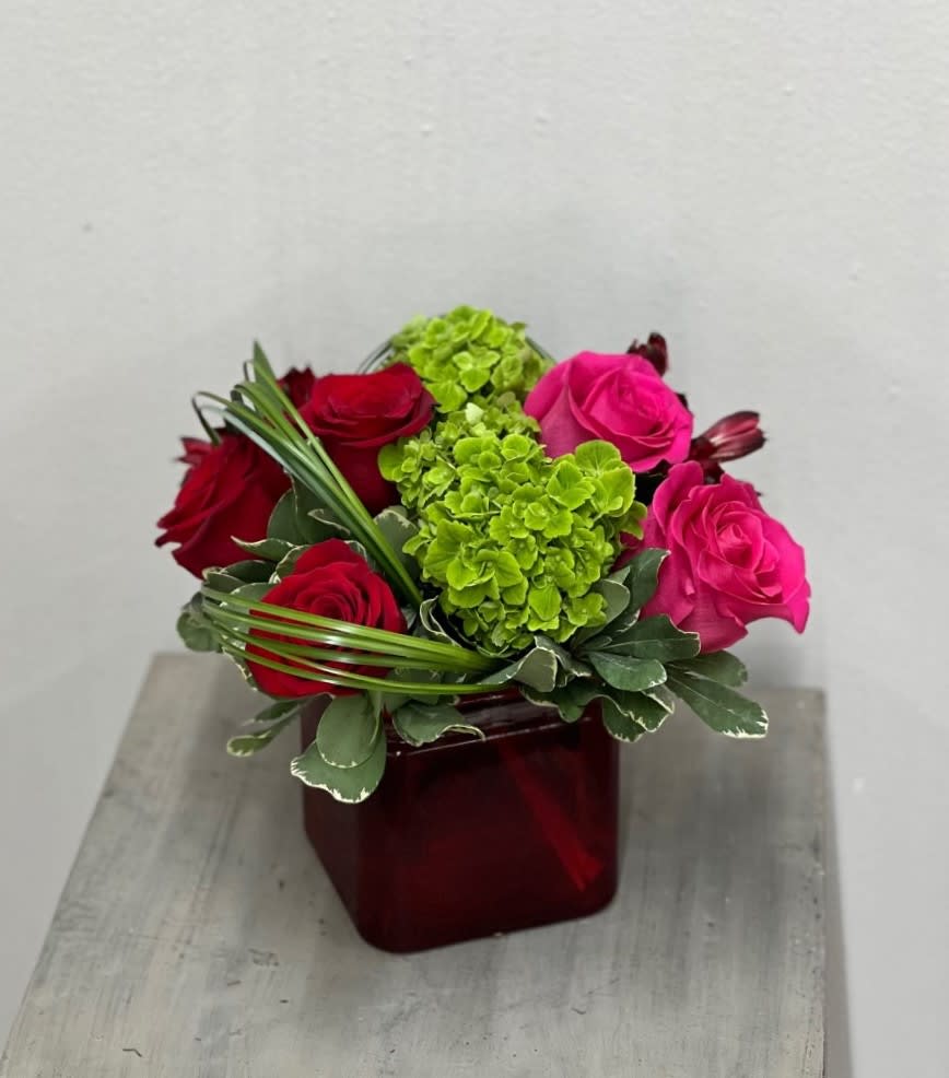 Love Letters Love Letters - Red roses, hot pink roses, green hydrangeas, red alstro tied together with greenery in a red cube are the perfect way to say I LOVE YOU. Not only that, but this arrangement has all the love in a compact style that is sure to bring life to a work desk, table, counter, etc... Flowers and colors may vary depending on availability.