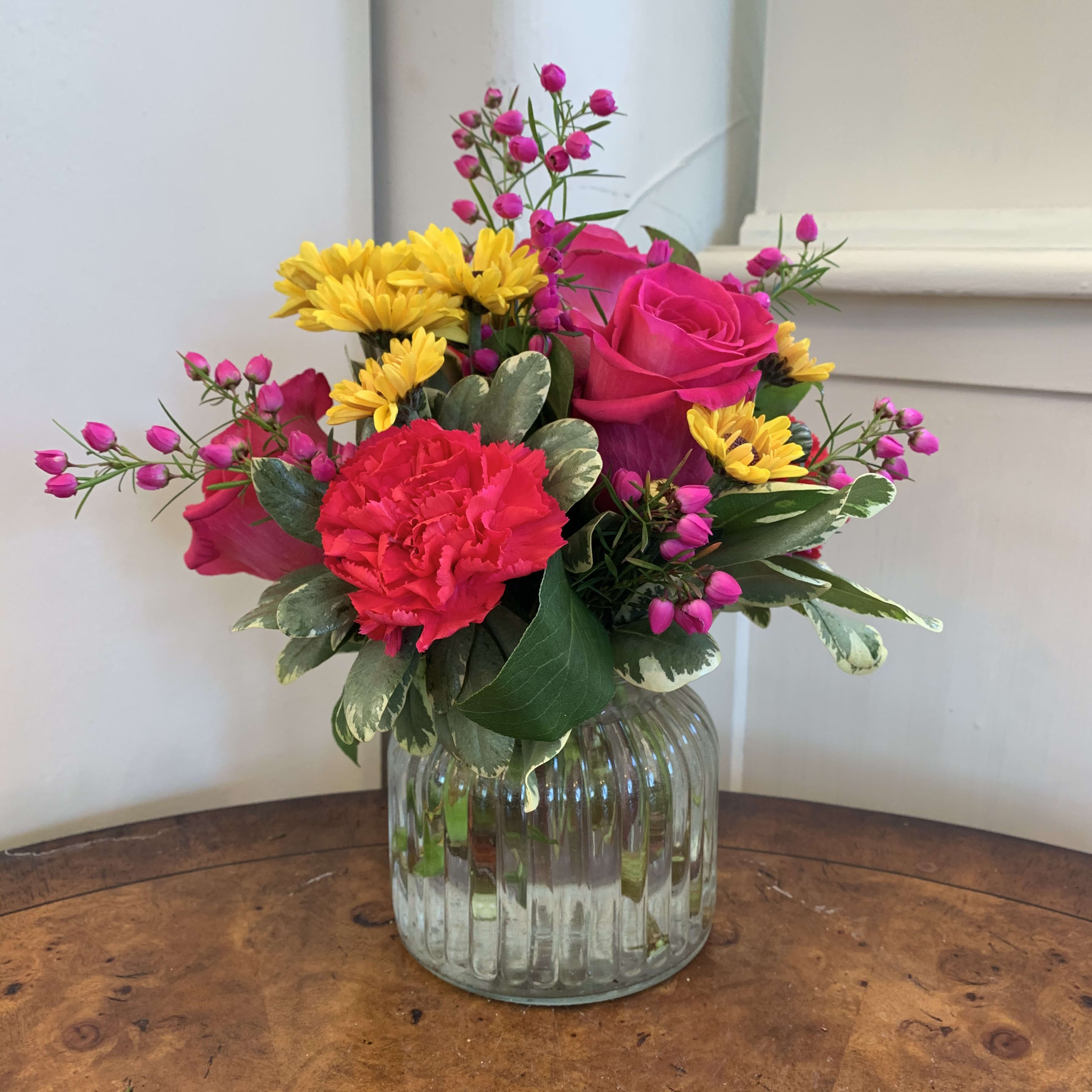Splendid Day Bouquet  - Hot pink roses, hot pink carnations, yellow daisies and beronia arranged in a small ribbed glass jar. Approximately 8in tall and 8in wide.  