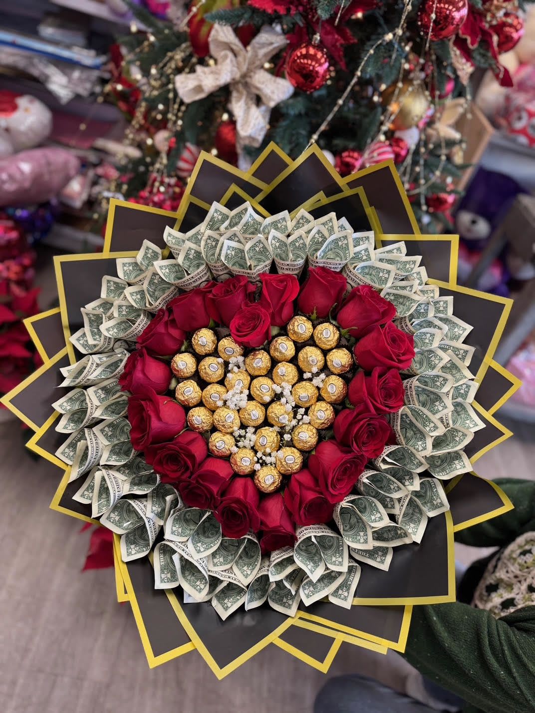VDAY 3 - IN this arrangement it contains $50's in 1's *** (Brought by Client)*** MUST PROVIDE OWN DOLLAR BILLS  18 roses of your choice of color with 35 chocolates which is one of our large boxes.   DISCLAIMER  For green and blooming plants, similar plants may be substituted of equal or greater value. For flowers, we will make every attempt to match the flower type / color but may substitute with another color or type of flower. If the container/ vase shown online is not available, a similar container/ vase will be used. Bears or other gift items may be substituted as well.  Want to check on availability? If it makes you feel more comfortable about the purchase, then we encourage you to call or email us to check on the latest availability of certain products. We would be glad to give you the most current, up-to-date status on our inventory.