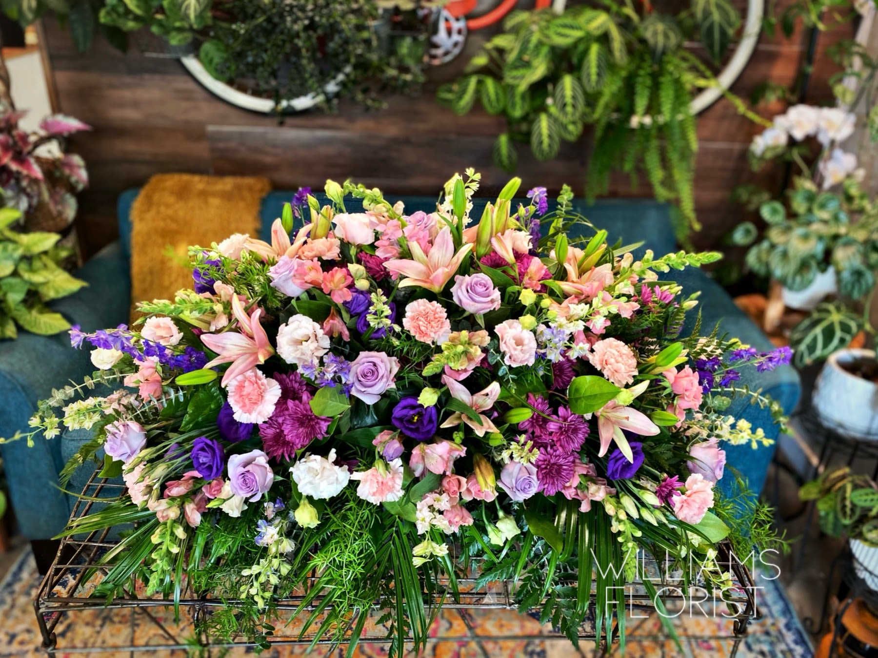 Lavender Tribute Lavender Tribute - Like a heartfelt embrace, this beautiful casket spray delivers comfort and love in an extraordinary way. A wonderful array of lavender and pink flowers with just the right amount of greenery is a lovely way to pay tribute to someone who will always be with you in heart, mind and spirit. Lovely lavender and pink roses, snapdragons, alstroemeria, chrysanthemums, fern, eucalyptus and more create this tribute that is overflowing with grace and love.
