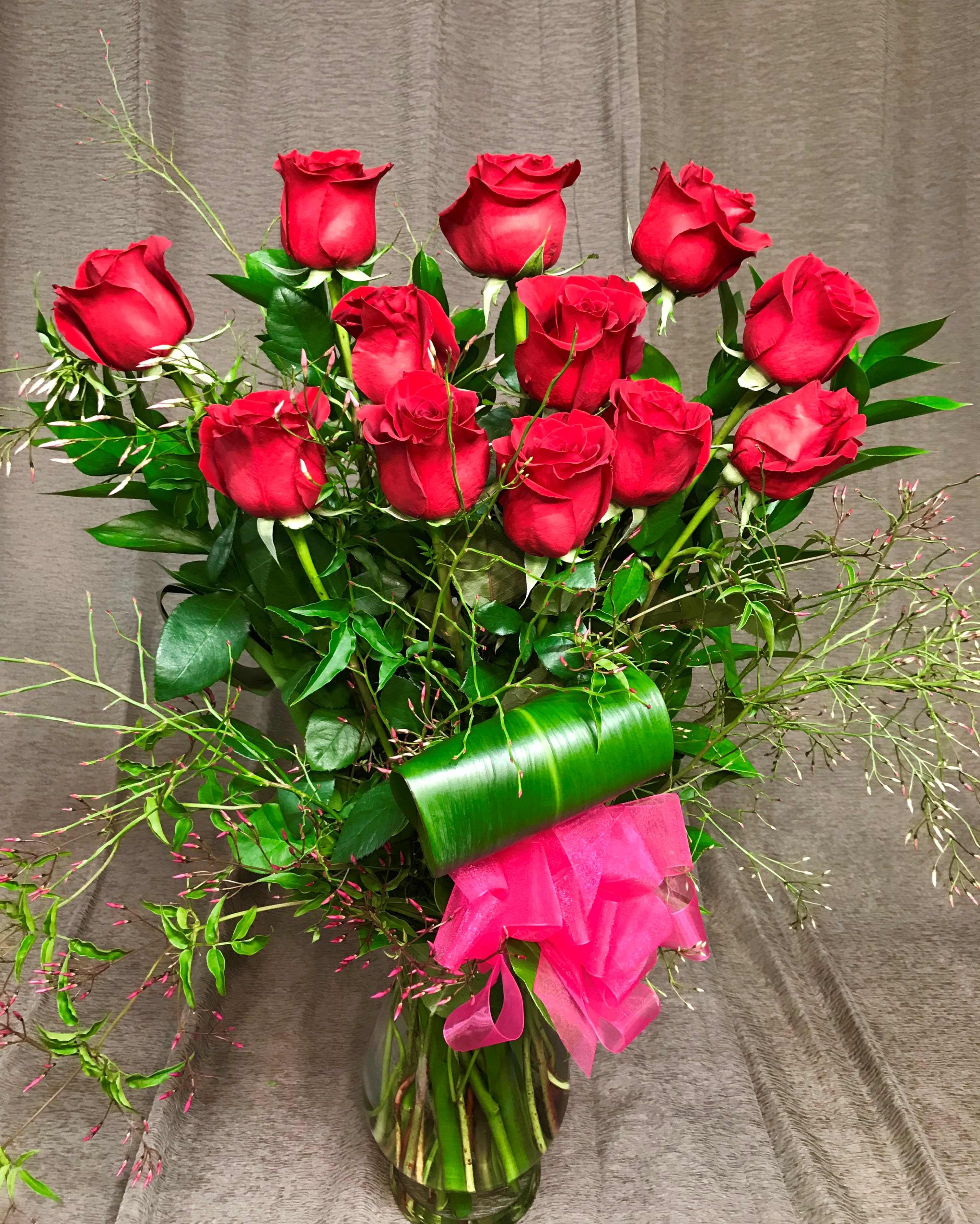 Deluxe Dozen Long Stem - Red or Colored - Deluxe means with more exotic greenery and filler flower selection. Red Dozen unless  1) Red is unavailable due to shorter than 48 hour notice on your order &amp; we will notify you if this is the case or  2) You Choose Colored.  Our premium vased dozen includes filler flowers, lush greenery a gorgeous bow and quality vase. We deliver our roses completely arranged so there is no fuss to find scissors. All of this is included; there are no hidden costs for the best, most perfect roses you will find. Vase, filler flowers and greenery may vary.   The roses we carry are Colombian roses and Ecuadorian roses, which are much bigger than red California roses.