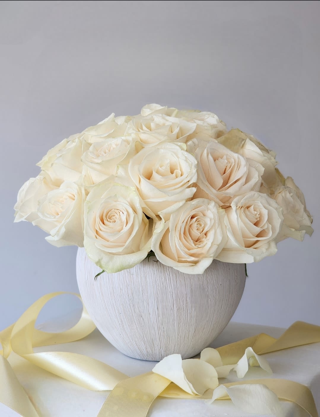 The Hollywood Smile - A charming and beautiful bouquet featuring pure white roses, elegantly presented in a white vase. 