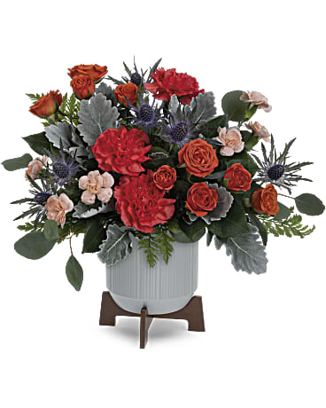 Teleflora's Retro Brights Bouquet - Sure to brighten Dad's day, Teleflora's Retro Brights Bouquet of radiant orange blooms looks sleek in a matte ceramic planter with retro-inspired wooden base. Orange spray roses, orange carnations, miniature peach carnations, blue eryngium and dusty miller are accented with silver dollar eucalyptus and leatherleaf fern. This Father's Day arrangement is delivered in Teleflora's Classic Contemporary planter.. Orientation: All-Around  SUBSTITUTION POLICY – Always deliver the freshest flowers! Please note the bouquet pictured reflects our original design.  If the exact flowers or container in this arrangement are not available, our local florists will create a beautiful bouquet with the freshest available flowers.