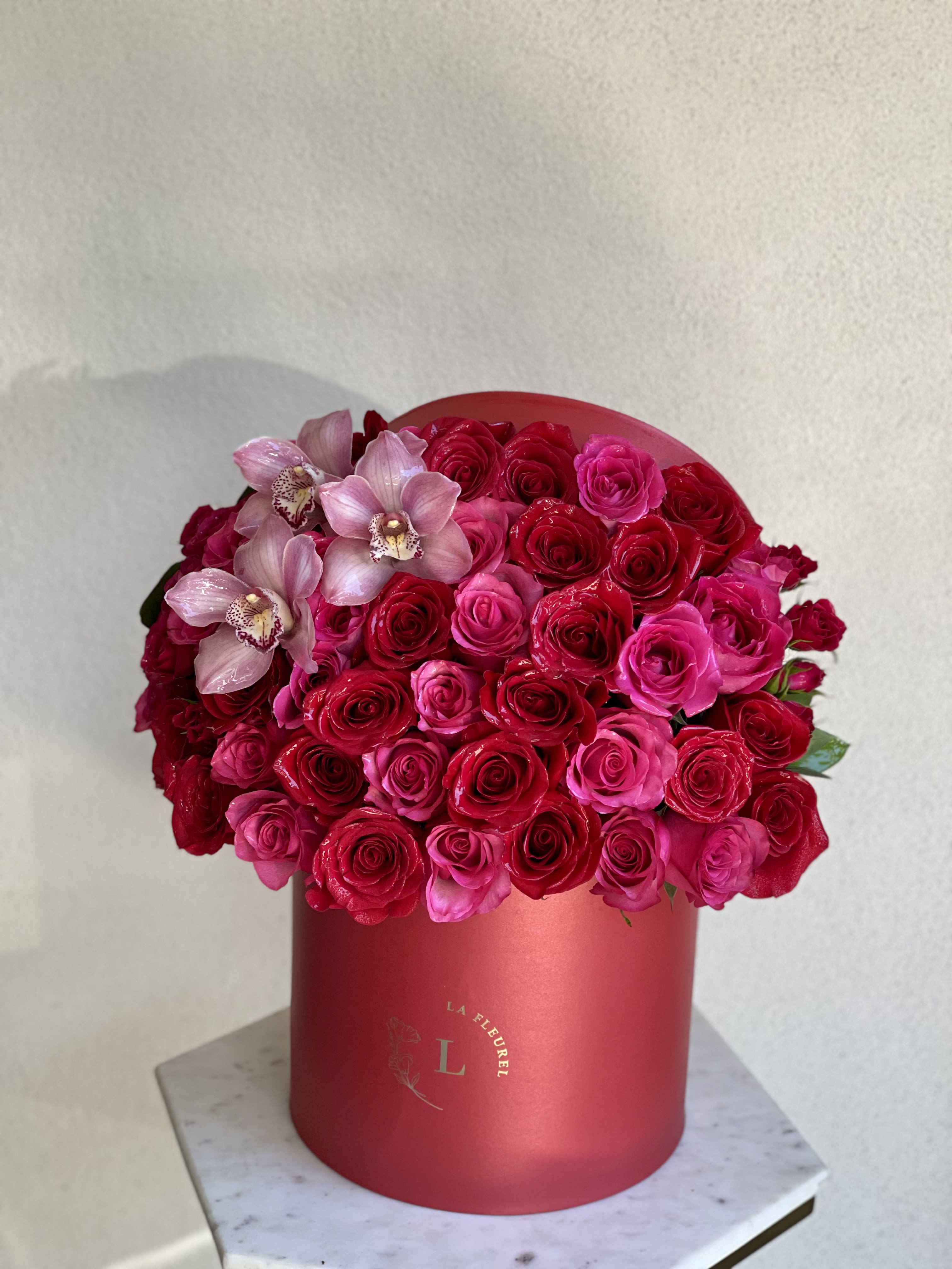 Passion Arrangement - This beautiful box contains a combination of 45 to 50 fresh roses and cymbidium orchids in a red box. This floral arrangment is the perfect gift for your loved one!  Large Size - 100 Roses  Arrangement includes: Fresh deep purple roses Medium box measured at 9.75&quot; Dia. x 9.25&quot; H Custom greeting card