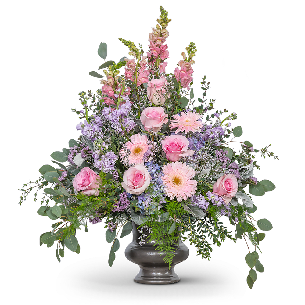 Glorious Garden Urn Glorious Garden Urn - Our Glorious Garden Urn is a breathtaking floral tribute that embodies the essence of a serene and enchanting garden. This meticulously designed arrangement combines delicate shades of pink and purple, harmoniously surrounded by lush green foliage, creating a truly awe-inspiring display. The soft hues of pink and purple reflect tenderness, compassion, and heartfelt emotions. This design reflects the cherished memories shared with your loved one, celebrating a life lived with grace and leaving a lasting impression of their extraordinary presence.