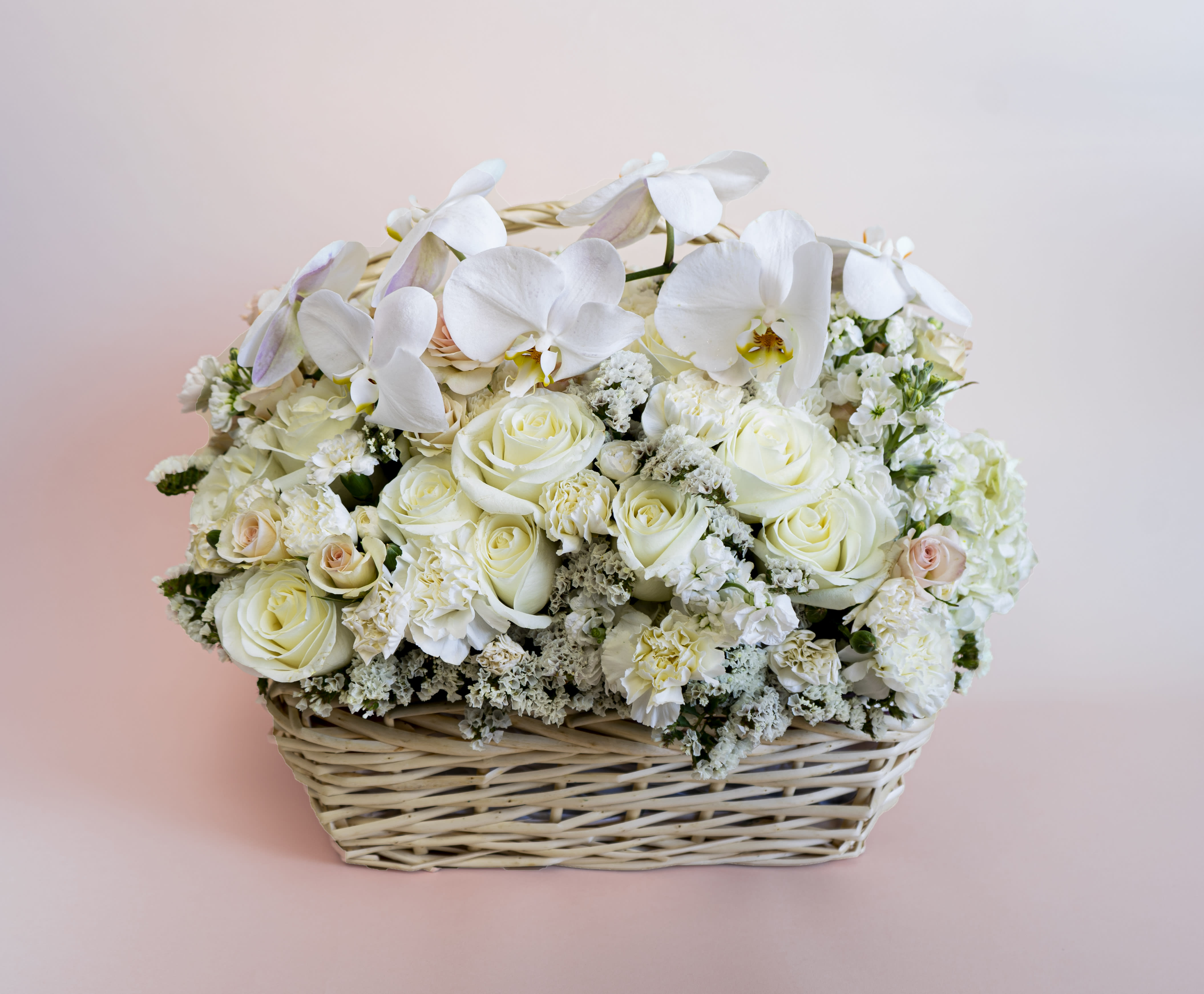White Perfection - Check out our a beautiful basket! This wicker basket is overflowing with white beauty and blossoms. Made with fresh cut roses and spray roses, hydrangeas and premium orchids.  This beautiful composition is perfect for sending to your favorite people for any occasion or no occasion at all!