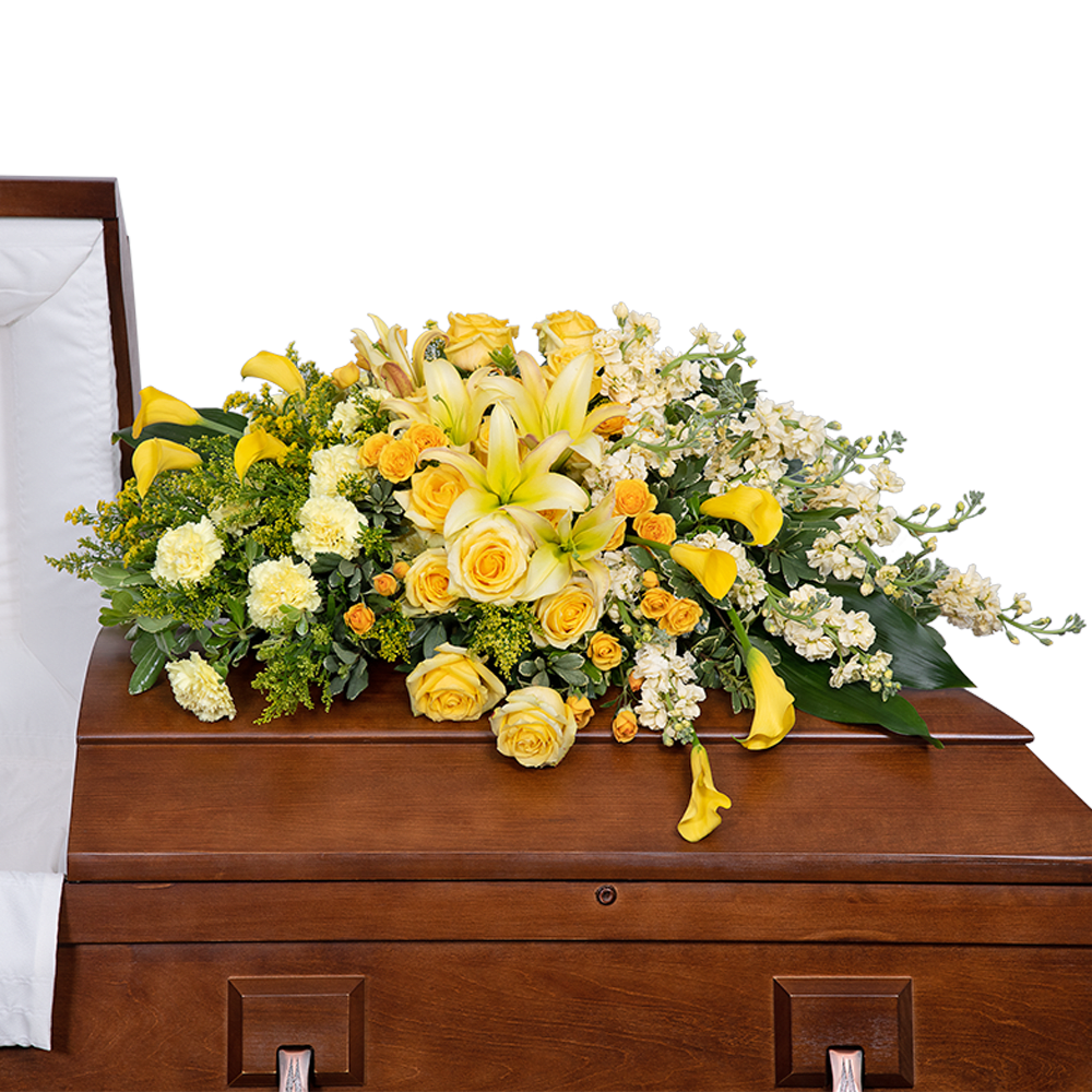 Radiant Remembrance Casket Spray Radiant Remembrance Casket Spray - Our Radiant Remembrance Casket Spray is a heartfelt tribute to honor and celebrate the life of your beloved friend or family member. Expertly crafted with care and reverence, this exquisite arrangement of funeral flowers serves as a radiant remembrance of their presence in our lives.The inclusion of these vibrant yellow blooms symbolizes the warmth, joy, and friendship your loved one brought to the lives of family and friends. Each carefully selected flower carries its own meaningful message, expressing love, gratitude, and remembrance during this time of loss.