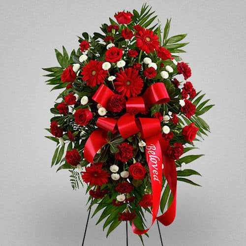 Treasured memories - This Treasured Life is a rich and colorful way to express your unending love and devotion to the deceased lift.  Ingredients:Red roses, burgundy carnations, burgundy mini carnations, red gerbera daisies and white button poms are accented with a variety of lush greens, with a wide red ribbon Vase: Presented on a wire easel. Size: Standard, Approximately 43&quot;h*27&quot;w Deluxe, Approximately 46&quot;h*30&quot;w Deluxe, Approximately 46&quot;H x 30&quot;W.