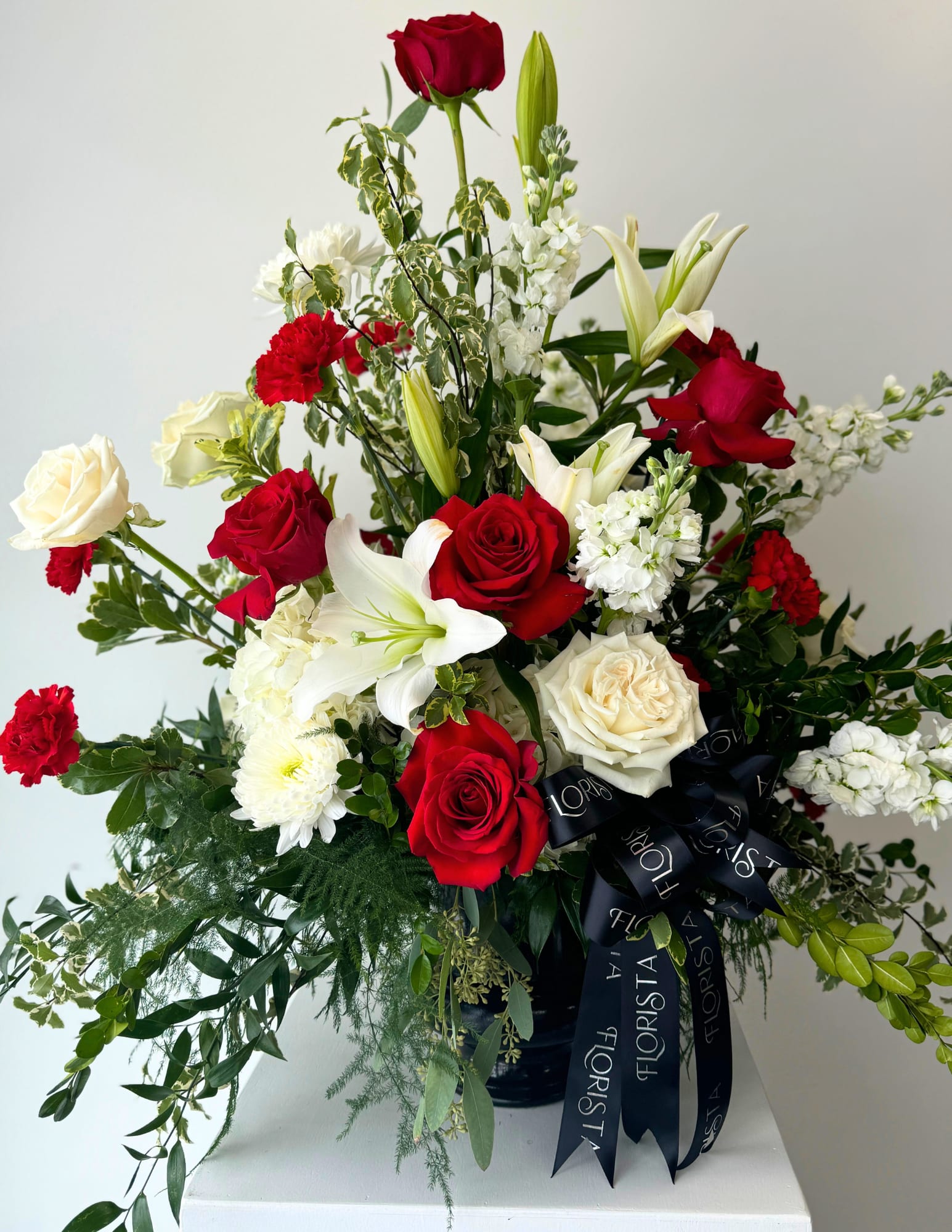 RED &amp; WHITE FUNERAL PIECE  - A graceful red and white funeral arrangement symbolizes love and remembrance. Featuring elegant white lilies, roses, and bold red blooms, offering comfort and peace during a time of loss