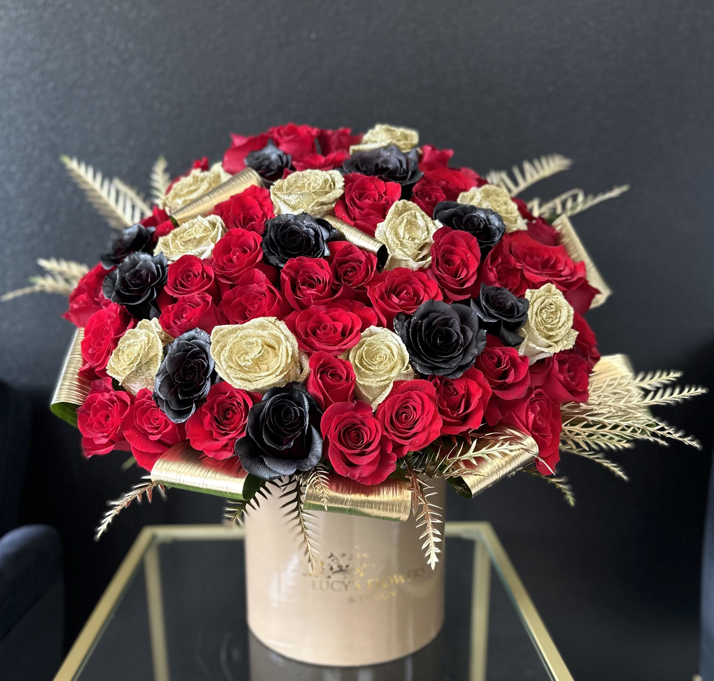 "To My Valentine" "To My Valentine" - Special roses for that special someone? Black, red and gold sparkle roses are designed and put together in our large signature box. A special way to show your Valentine how much you love and appreciate them on this special Day! Arrangement Includes: -Fresh Cut Roses -Lucy's Signature Large Size Box -Custom Greeting Card -Care Instructions