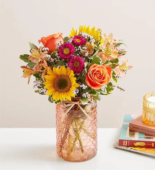 Summer Mason Jar - Our delightful bouquet captures the season’s vibrant beauty. A happy mix of pink, yellow, orange and peach blooms is loosely gathered in our peach quartz mason jar, adding sweetness and charm with its honeycomb pattern and raffia bow. For gathering, celebrating or just connecting, it’s a gift that captures that endless summer feeling.