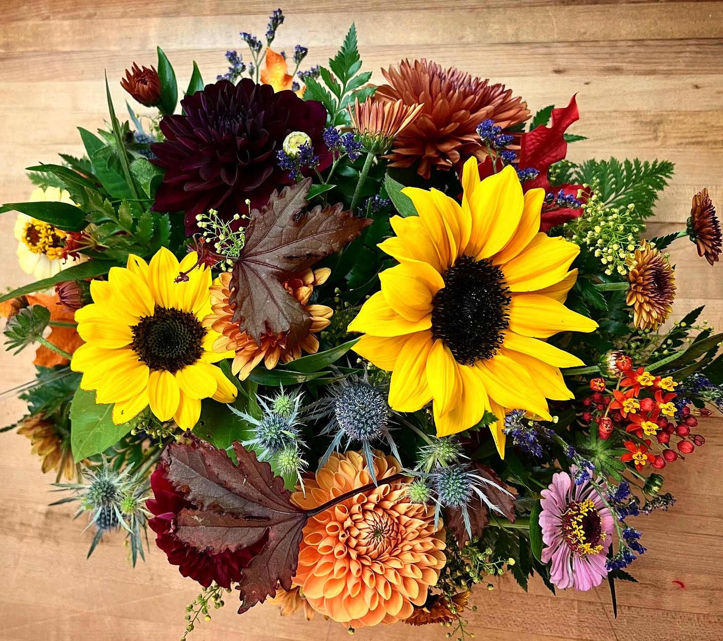 Autumn light - This gorgeous fall centerpiece is made up of sunflowers, dahlias, and seasonal flowers.   