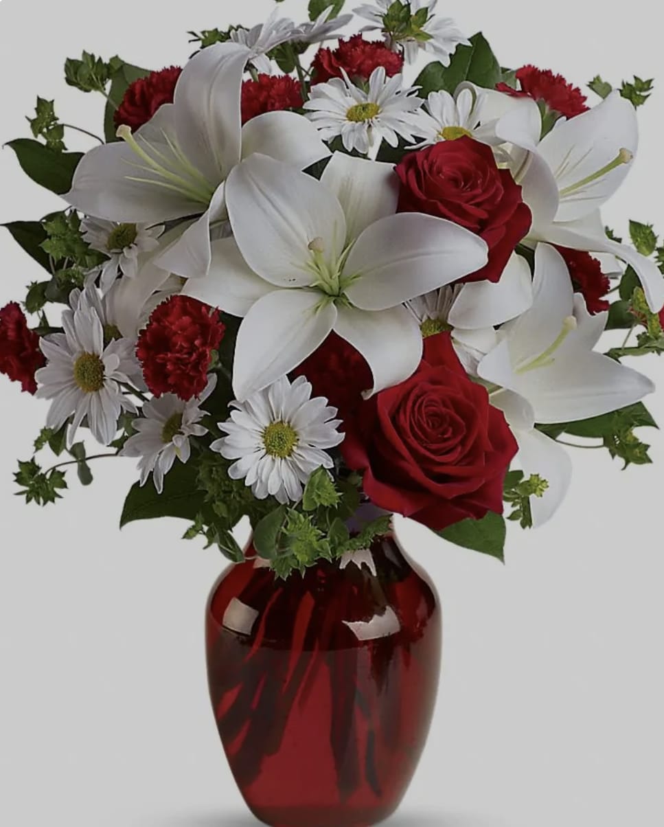Kiss me Kiss me - This beautiful arrangement made of roses in your choice of color, white lilies, carnations and Daisy palms would definitely earn that kiss