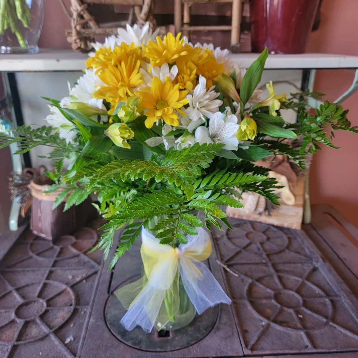  Upsie Daisy - What could be sweeter than a cheerful glass vase filled with white and yellow daisies? Can't think of anything? Then choose this sunny bouquet. It will brighten their day. The bright bouquet includes white daisy spray chrysanthemums yellow daisy spray chrysanthemums and bupleurum accented with fresh greenery. Delivered in clear glass vase tied with a yellow ribbon.