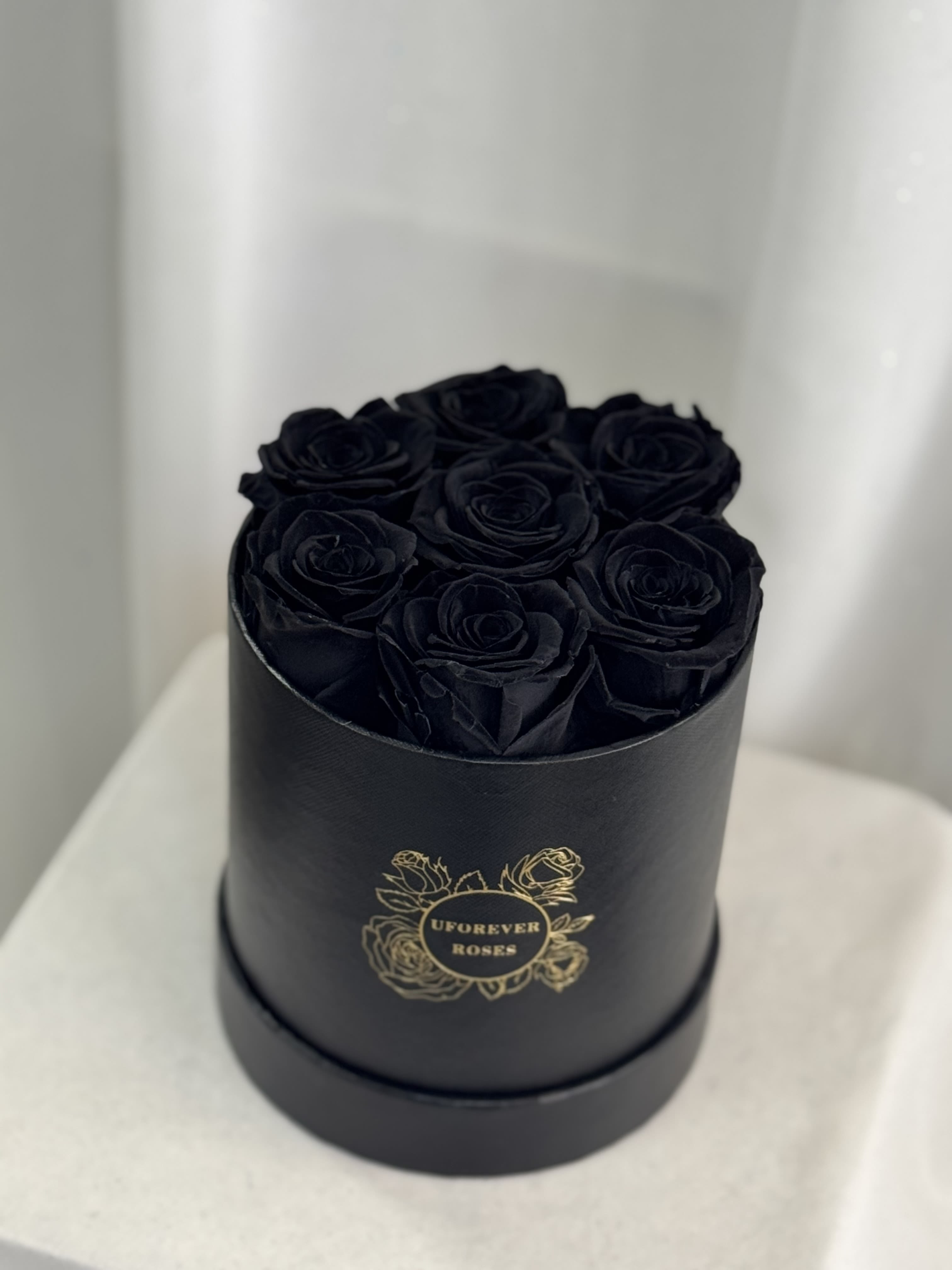  Forever Roses in Black  - A lasting luxurious gift of roses, that will impress your special someone and bring them joy every time they see them.  A beautifully quality preserved rose chosen at the peak of perfection and then preserved to maintain the original natural beauty of each unique rose. A luxurious and romantic gift of love and adoration to cherish over time. They are preserved and, with proper care, will stay just as beautiful for up to a year or longer.  Care Instructions: Arrangements do not require watering; for maximum beauty, keep away from extreme sunlight &amp; humidity  Roses and hat box arrive inside a decorative gift box with ribbon.  Item dimensions Height x Diameter: 7in x 5.5in 7 Black Roses 