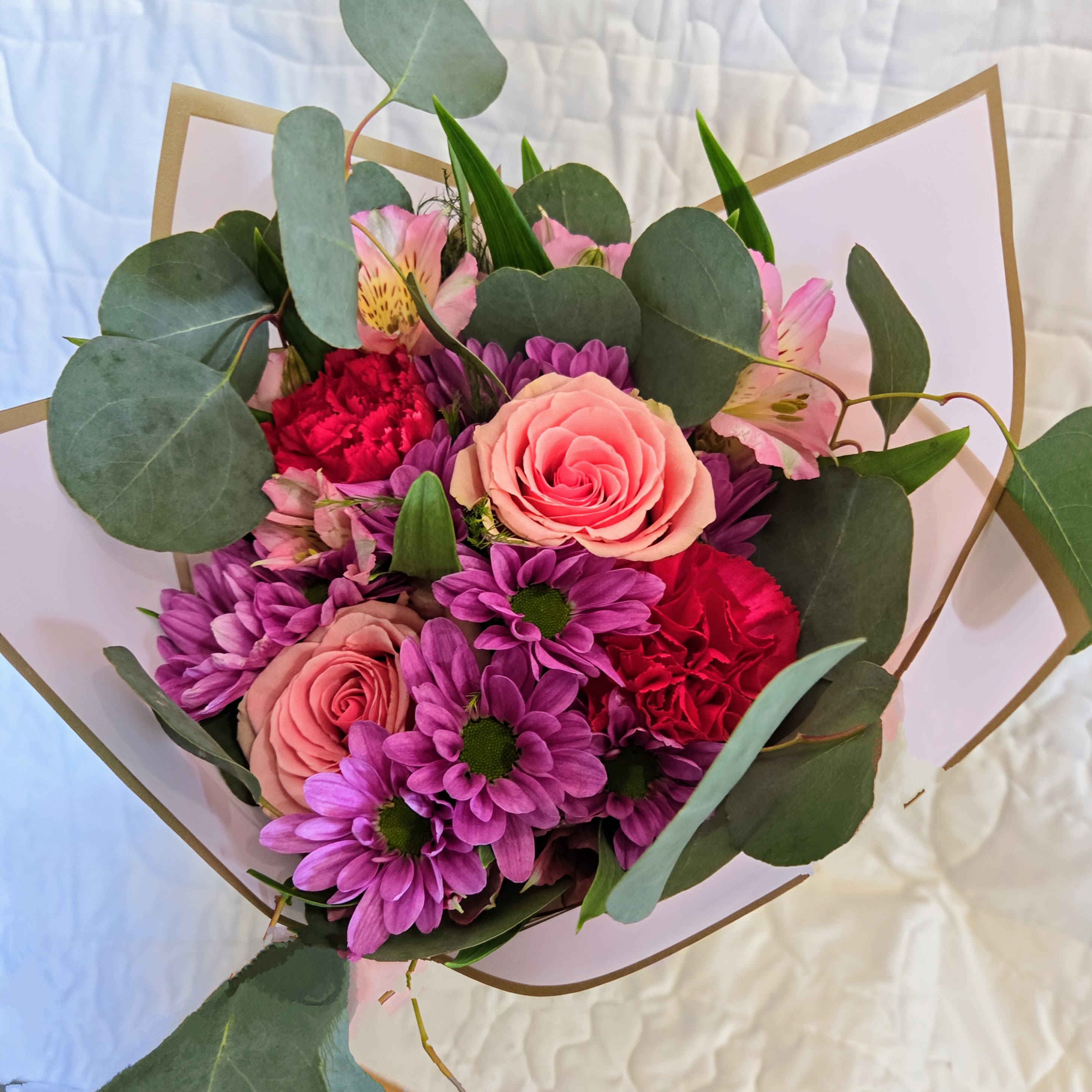 Opal-Wrapped Bouquet - This beautiful wrapped bouquet is made with a mixture of seasonal flowers and colors of designers choice. Wrapped with a hand tied bow.
