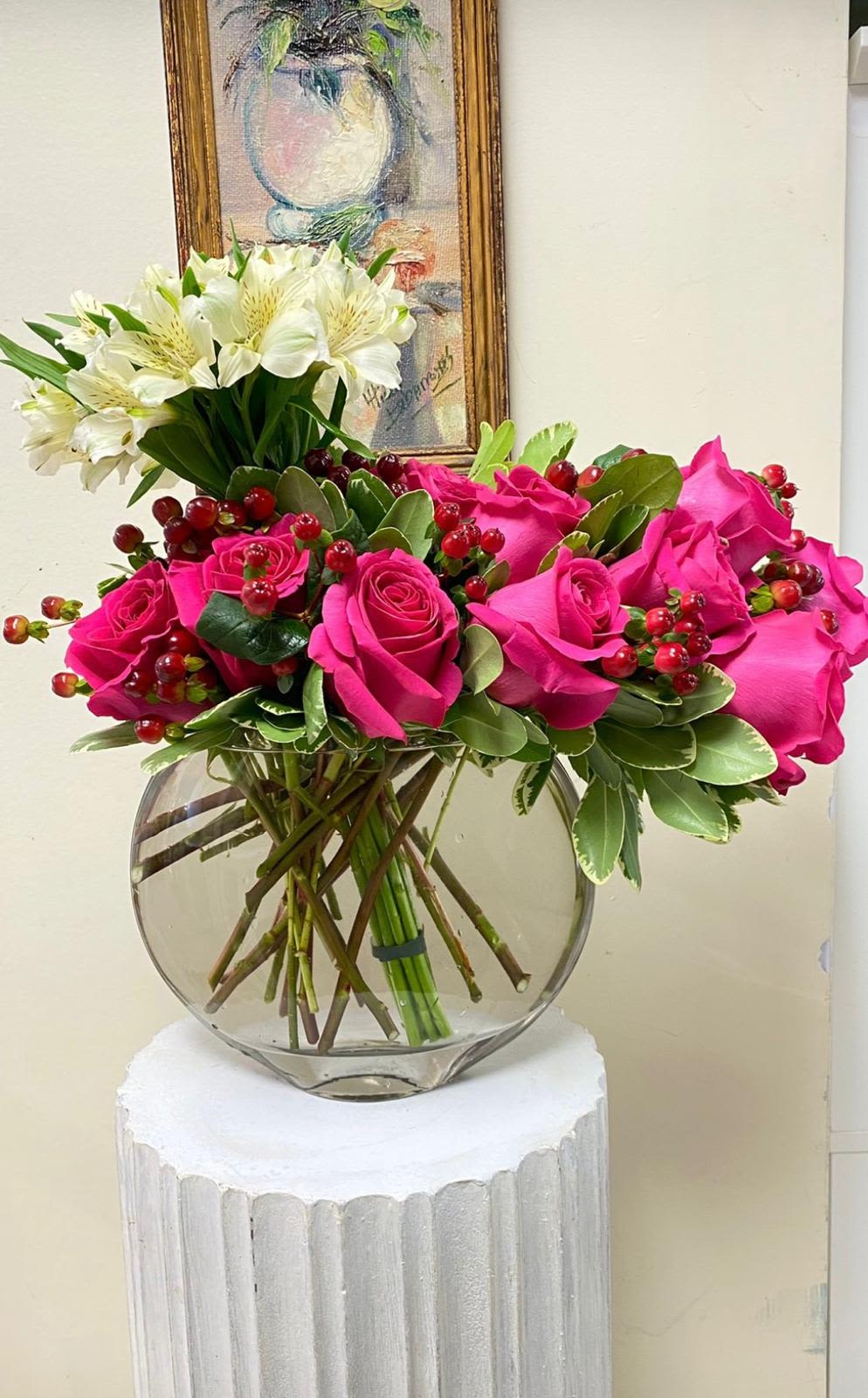 Tropical Bliss Tropical Bliss - Sumérgete en la belleza exótica de este arreglo floral, que combina la elegancia de las rosas fucsias con la frescura de las pepitas rojas y la pureza de las astromelias blancas. La base de cristal redonda refleja la luz y realza la belleza de las flores, creando un efecto visual impresionante que llenará cualquier espacio de alegría y sofisticación. Un arreglo perfecto para celebrar una ocasión especial o simplemente para agregar un toque de elegancia a tu hogar."