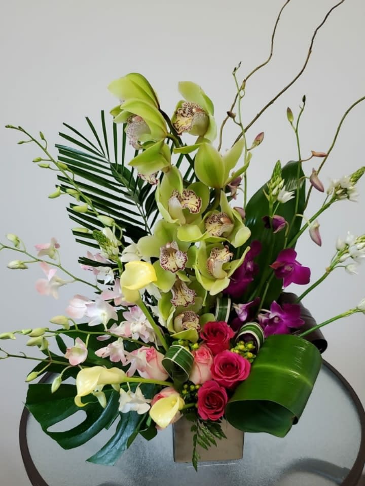 Orchid Fantasy Orchid Fantasy - Beautiful ideal arrangement to give on a birthday, anniversary and any special date for that person you love so much. Made with green orchids, roses, calla lilies and more. Show your love with this incredible flower arrangement Request one day in advance Flowers and similar colors