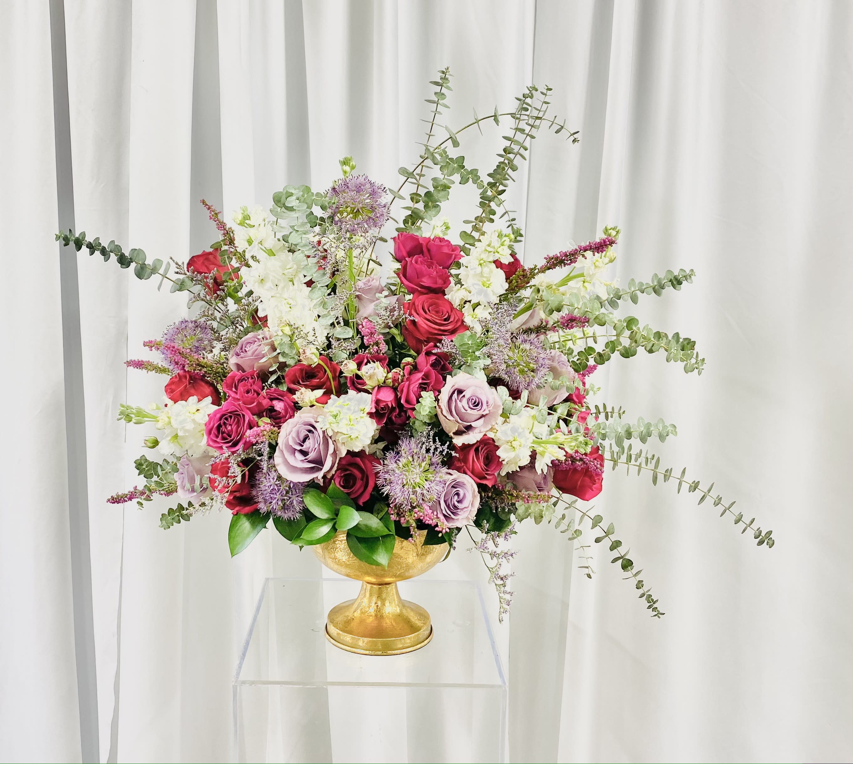 Burst of Spring - Beautiful full display of bright flowers bursting with spiral baby blue eucalyptus.  Flowers consisting of stock, roses, spray roses, allium, veronica, and greenery.  Design displayed in a neutral colored vase.