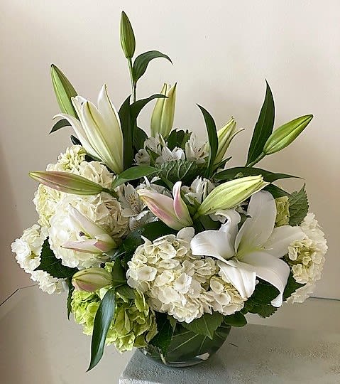 Beautiful in White Centerpiece - White flowers as shown arranged round in a vase. The quantity of flowers increase with Deluxe and more for Premium. Photos shown are Standard and Premium version. 