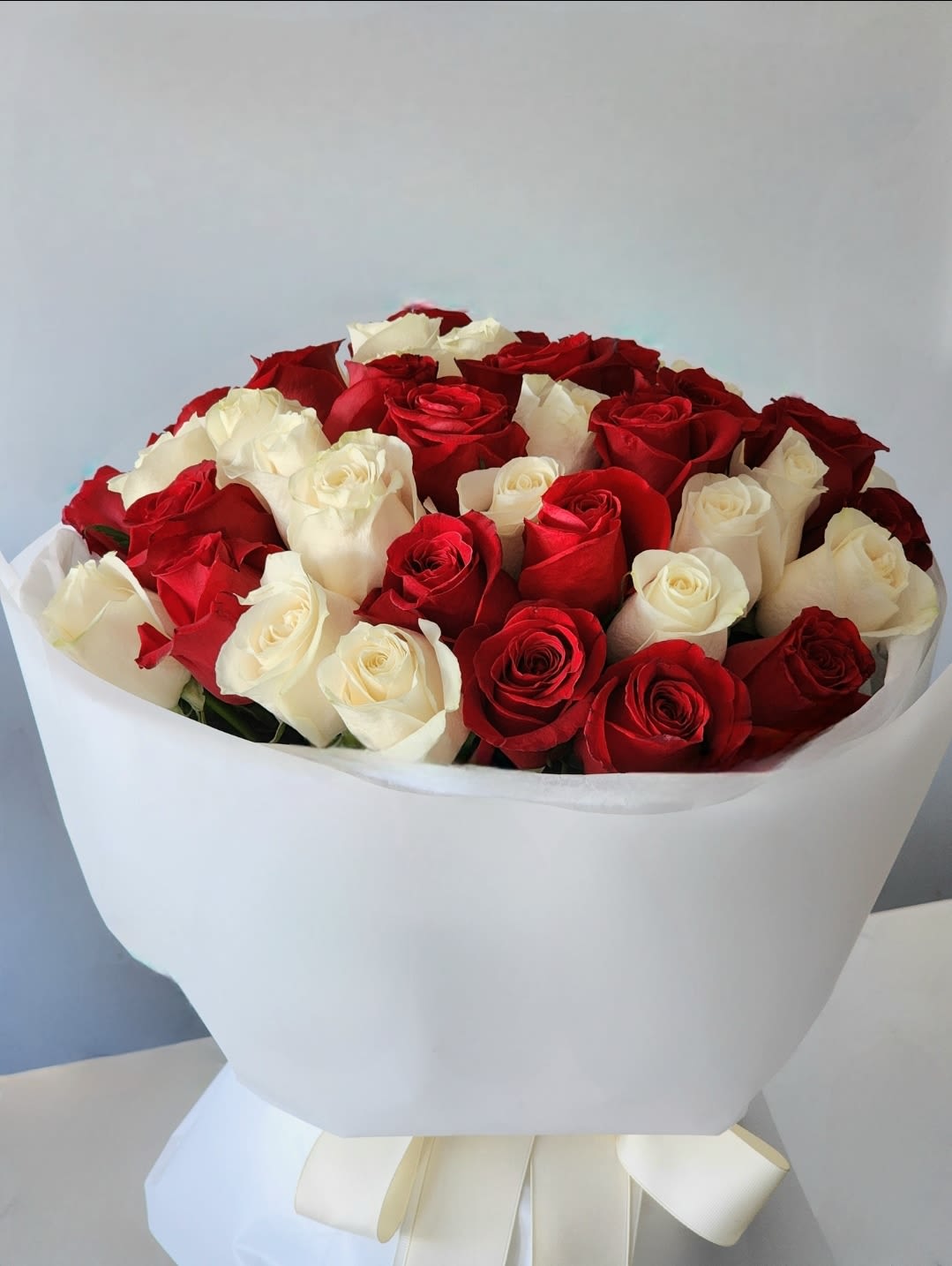 Heart and Soul - Discover the perfect blend of charm and sophistication with red and white roses bouquet. Wrapped in elegant, this bouquet is more than flowers – it's a heartfelt experience.
