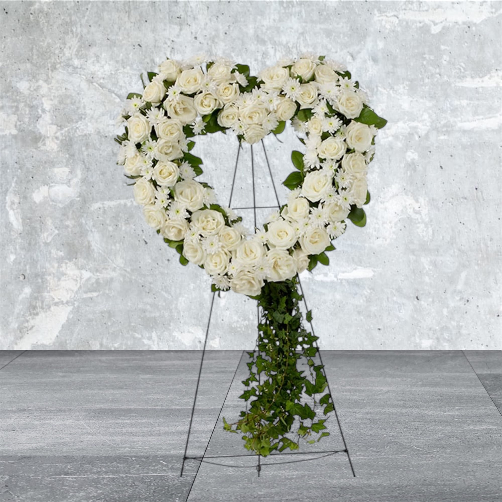 Love in our Hearts - An all white tribute, this heart shaped easel shows your everlasting love. Featuring a variety of white flowers and greenery, this heart with a trail of ivy compliments the beauty of life. 