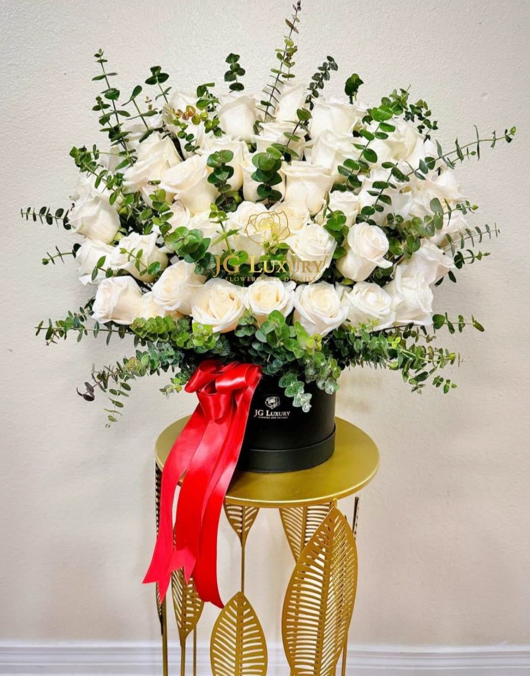Luxury Box White Edition - A stunning flower arrangement of white roses and eucalyptus branches displayed in one of our Luxury Boxes, perfect for the occasion of your choice.