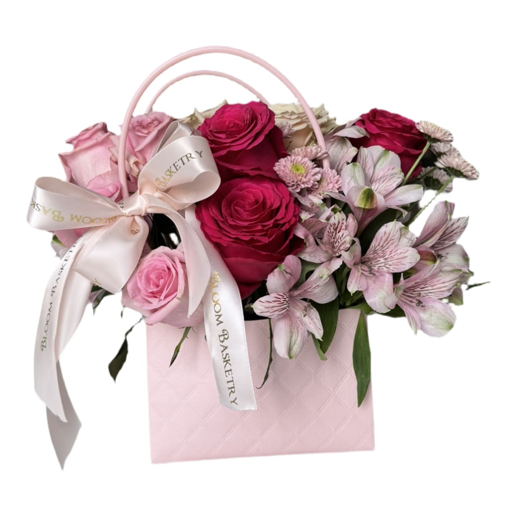 Lulu Bag  - This elegant floral arrangement features soft, blush roses as the centerpiece, their velvety petals paired beautifully with the vibrant, multicolored blooms of alstroemerias. The delicate, arching greenery of ruscus adds a touch of sophistication, framing the flowers with a lush, textured backdrop. The overall composition is a harmonious blend of warmth and freshness, perfect for conveying love, appreciation, or celebration.