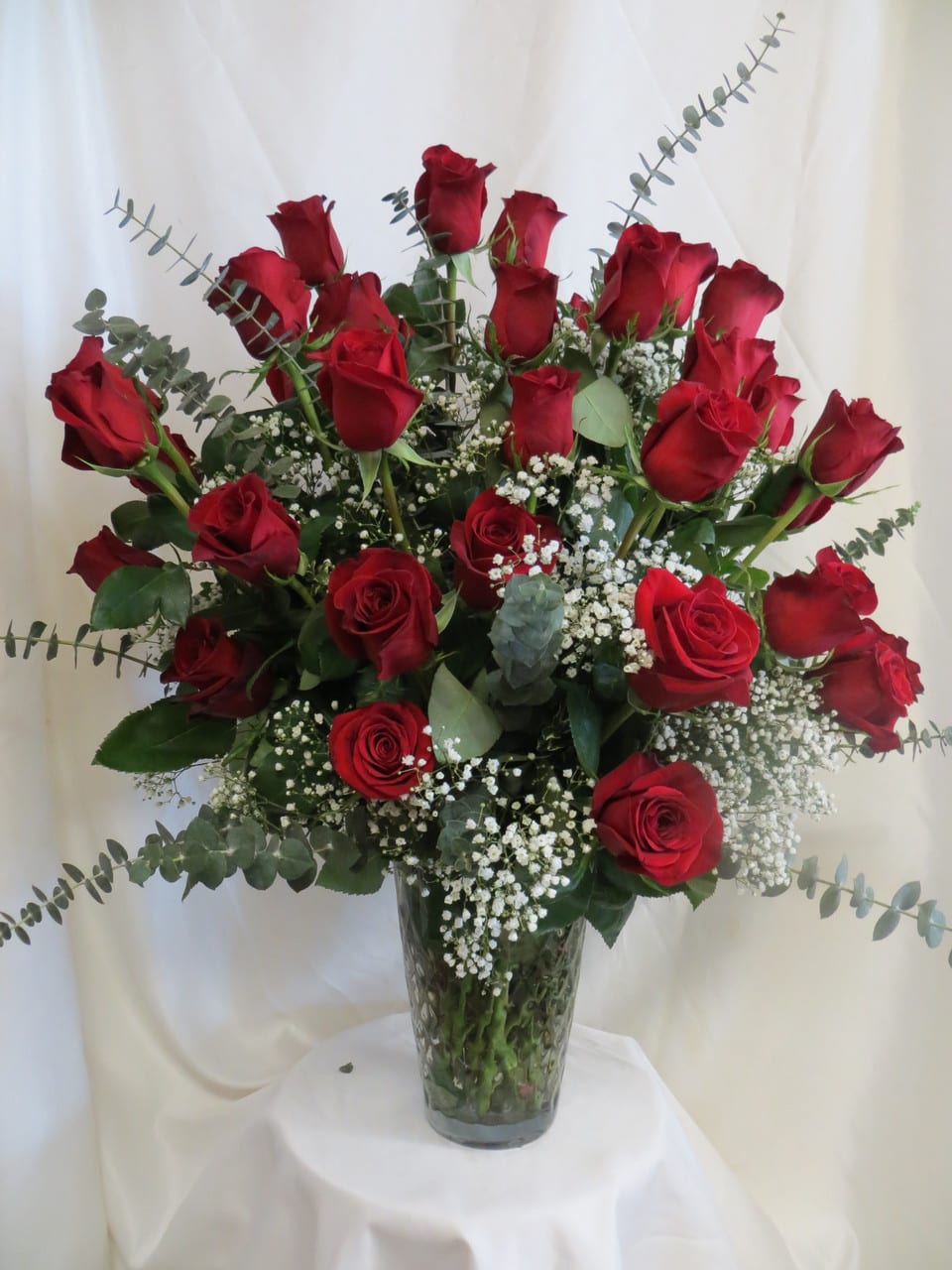 3 DOZEN RED ROSES NEW-R42 3 DOZEN RED ROSES NEW-R42 - Our 3 dozen rose arrangement is a monumental expression of your love. 36 extra long stem red roses with quality greens and white babies breath comes in a large, heavy, quality, glass vase. This dramatic arrangement makes a bold statement and is also great for any party occasion as a centerpiece.. This arrangement is made to be view all the way around. We can also make much larger rose arrangement in even larger containers and in other colors. For all your special colors or custom order needs phone us at 1800-331-5358