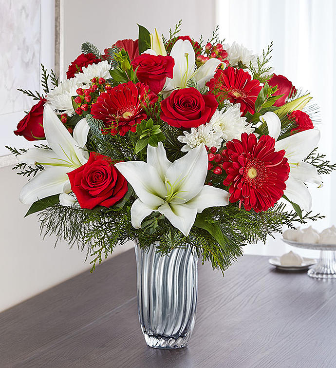 Christmas Celebrations Christmas Celebrations - Crystal vase filled with red roses, white lilies, red gerbera, mums and evergreens