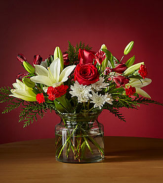 HOLIDAY VACATION BOUQUET HOLIDAY VACATION BOUQUET - UPGRADED CLEAR VASE WITH WHITE LILIES, RED ROSES, RED ALSTROMERIA, WHITE MUMS AND RED MINI CARNATIONS