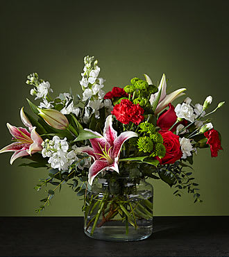 PEPPERMINT SWIRL BOUQUET PEPPERMINT SWIRL BOUQUET - UPGRADED GLASS VASE WITH STARGAZER LILIES, WHITE STOCK, RED ROSES, RED CARNATIONS, AND WHITE MINI CARNATIONS