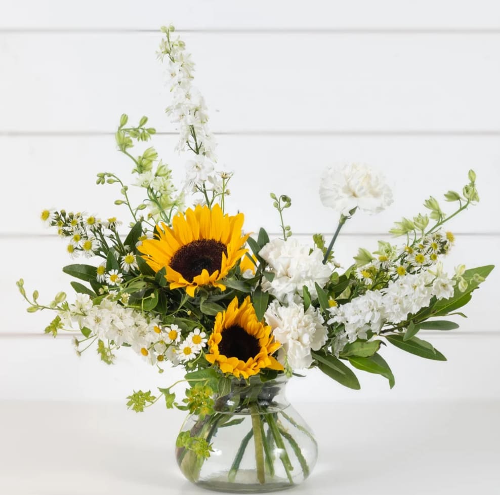 Sunny Meadow - The only thing this meadow-inspired design is missing is a fresh breeze, the warmth of the sun, and the buzz of bees. Sip on a glass of lemonade over this mix of sunflowers and seasonal fillers that will surely delight its recipient.  Florist reserves the right to make modifications to the design based on seasonality and accessibility of blooms and vases. Any modifications made will honor the palette, intent, and feeling of the pictured design.  Kindly contact us directly with any specifications or concerns.  