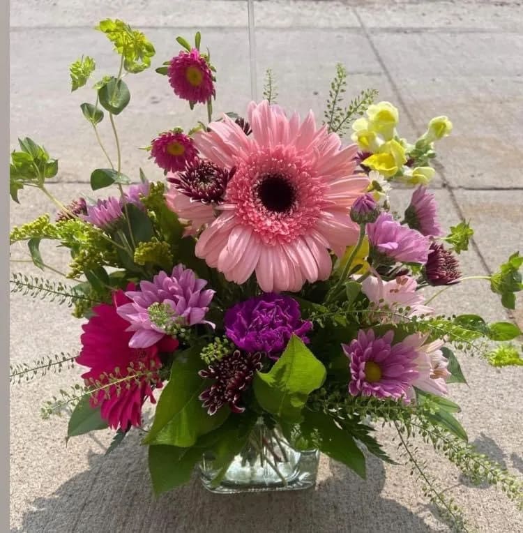 Light of my Life Light of my Life - This sweet bouquet comes in a cube vase, perfect for the table or her desk. It includes flowers such as Gerber daisies, carnations. daisies, and a variety of greens. Note: We make our arrangements as close to the pictures as we can with what we have available to us. We may make substitutions for flower variety but try to keep the colors pattern the same.