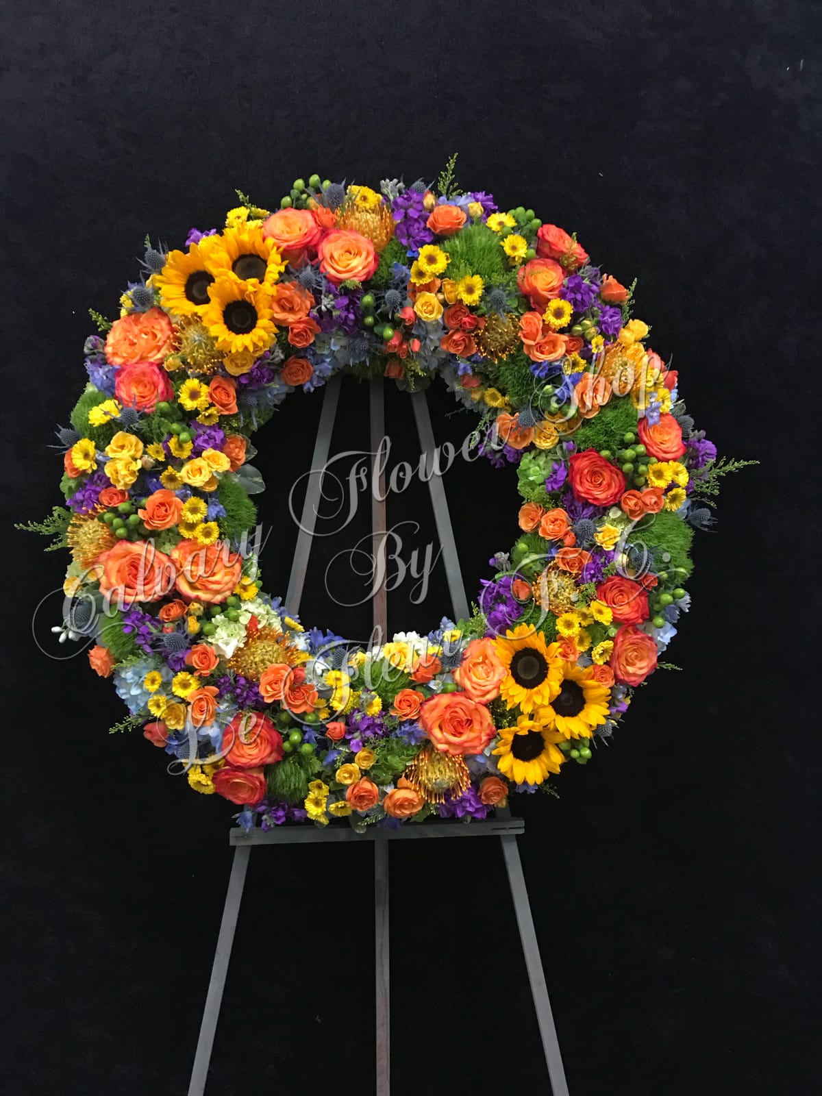 Sympathy of Colors Wreath Sympathy of Colors Wreath - A beautiful sympathy wreath filled with various vibrant flowers of spring mixed colors. (Standard Size Shown)