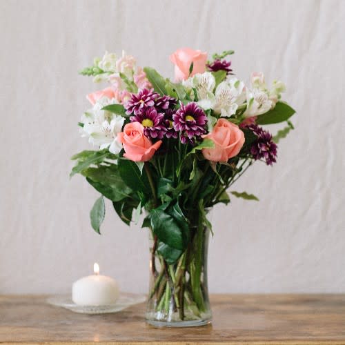Sweet Sentiments - One out our best sellers, this vase will bring a burst of color into any room!  A combination of purple daisy poms, snapdragons, alstromeria, and light pink roses, a sure delight!