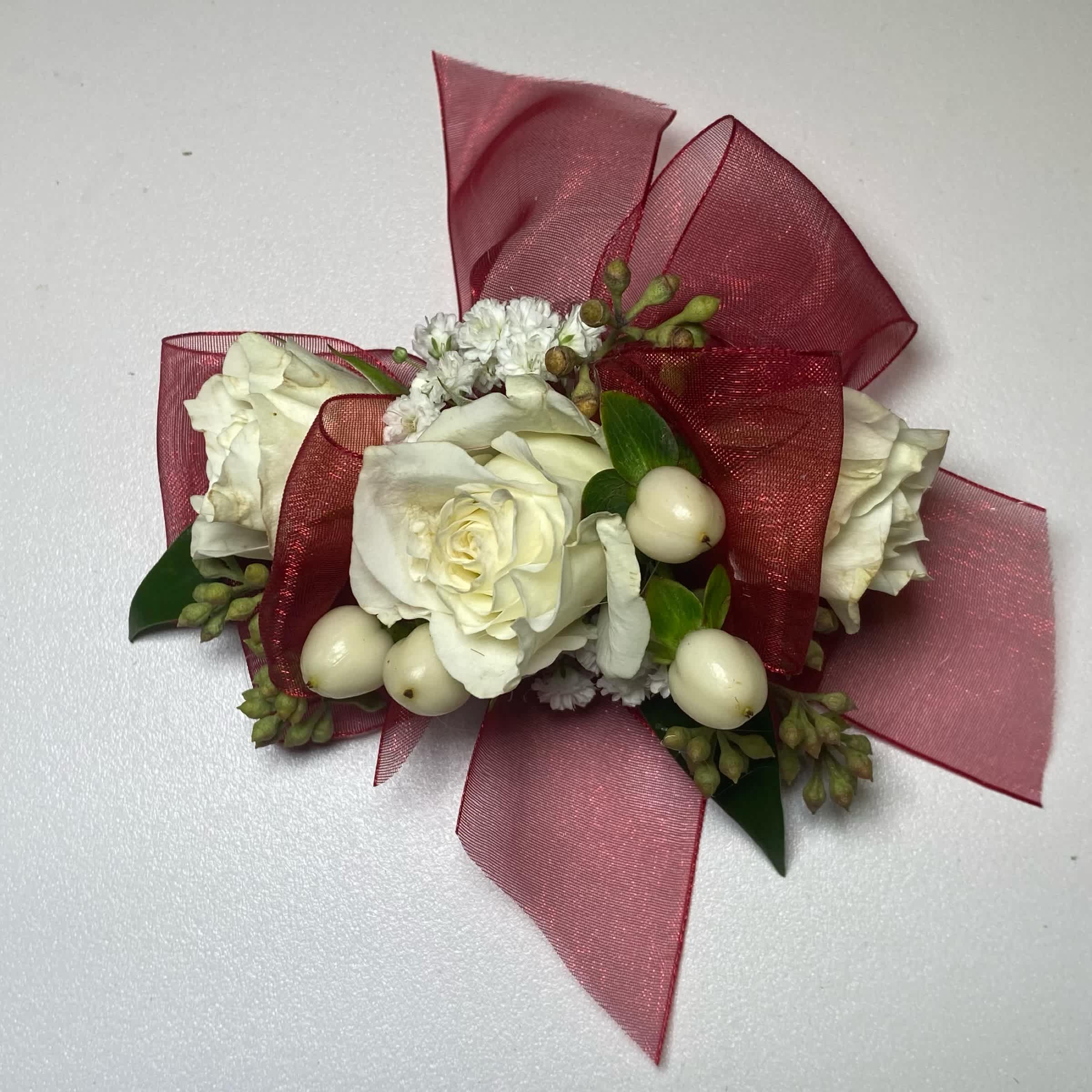 Cranberry/ White Rose Wrist Corsage – Prom/ Wedding - This White Rose Corsage Includes an Adult Size Elastic Wristband, Cranberry Chiffon Ribbon, White Spray Roses, Hypericum Berries, Gentle Greenery and Seeded Eucalyptus. Or as Similar as Possible.