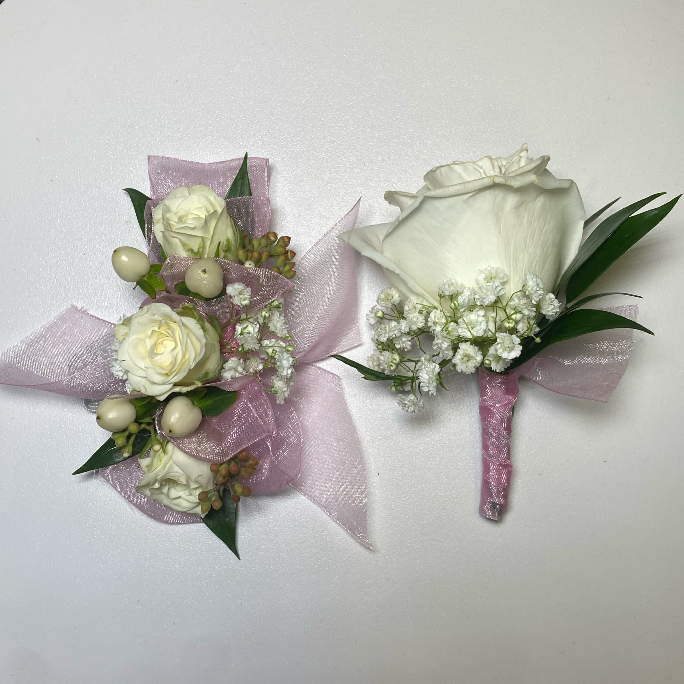 Light Pink Set - Prom/ Wedding - This White Rose Corsage and Boutonniere Includes an Adult Size Elastic Wristband Corsage and Magnetic Boutonniere with Hunter Green Chiffon Ribbon. The Corsage Includes White Spray Roses, Hypericum Berries, Gentle Greenery and Seeded Eucalyptus. The Boutonniere includes a White Rose with Babies Breath and Gentle Greenery. Or as Similar as Possible.