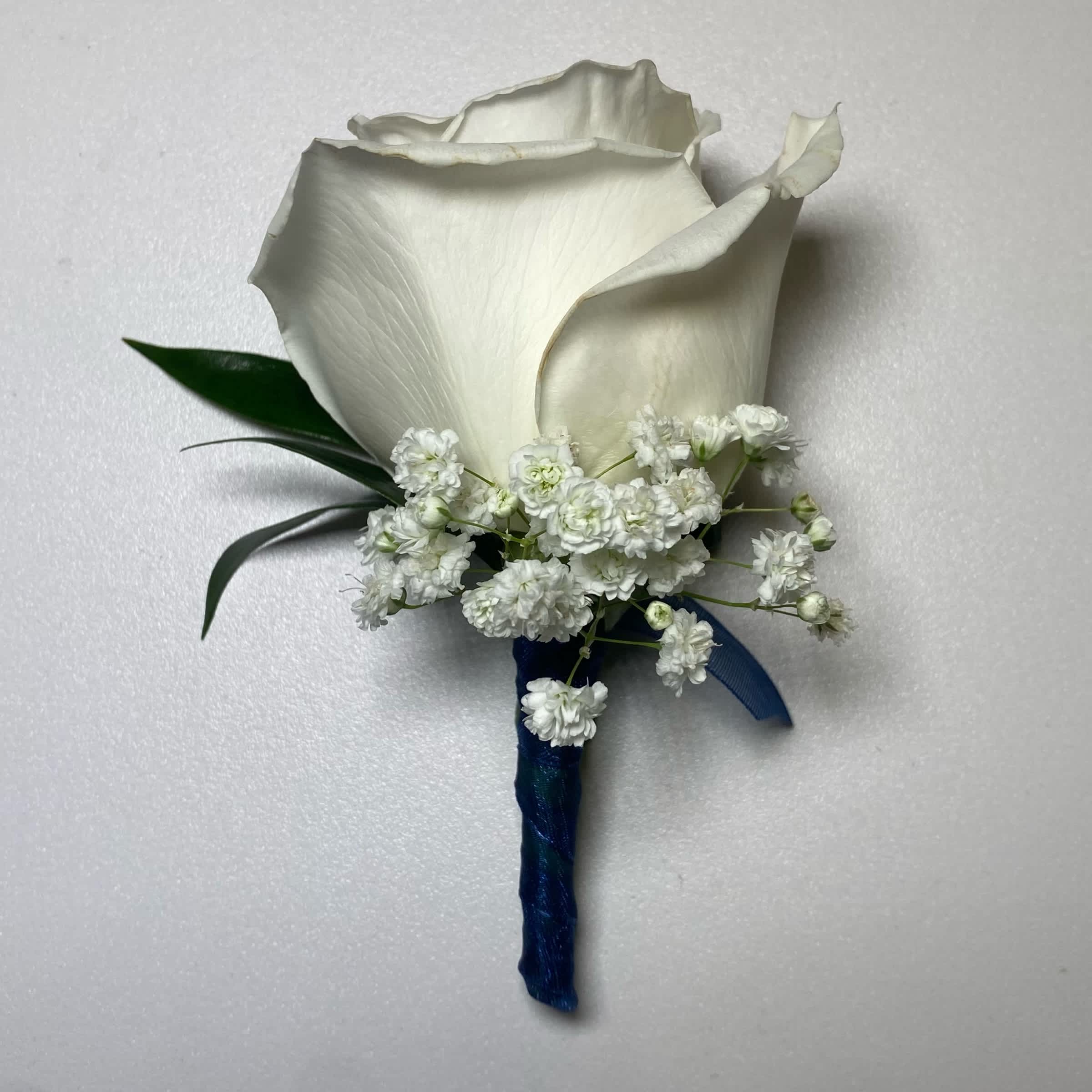 Navy Blue/ White Rose Boutonniere  - This White Rose Boutonniere Includes, Navy Blue Chiffon Ribbon, White Rose, Babies Breath, and Gentle Greenery. Or as Similar as Possible.