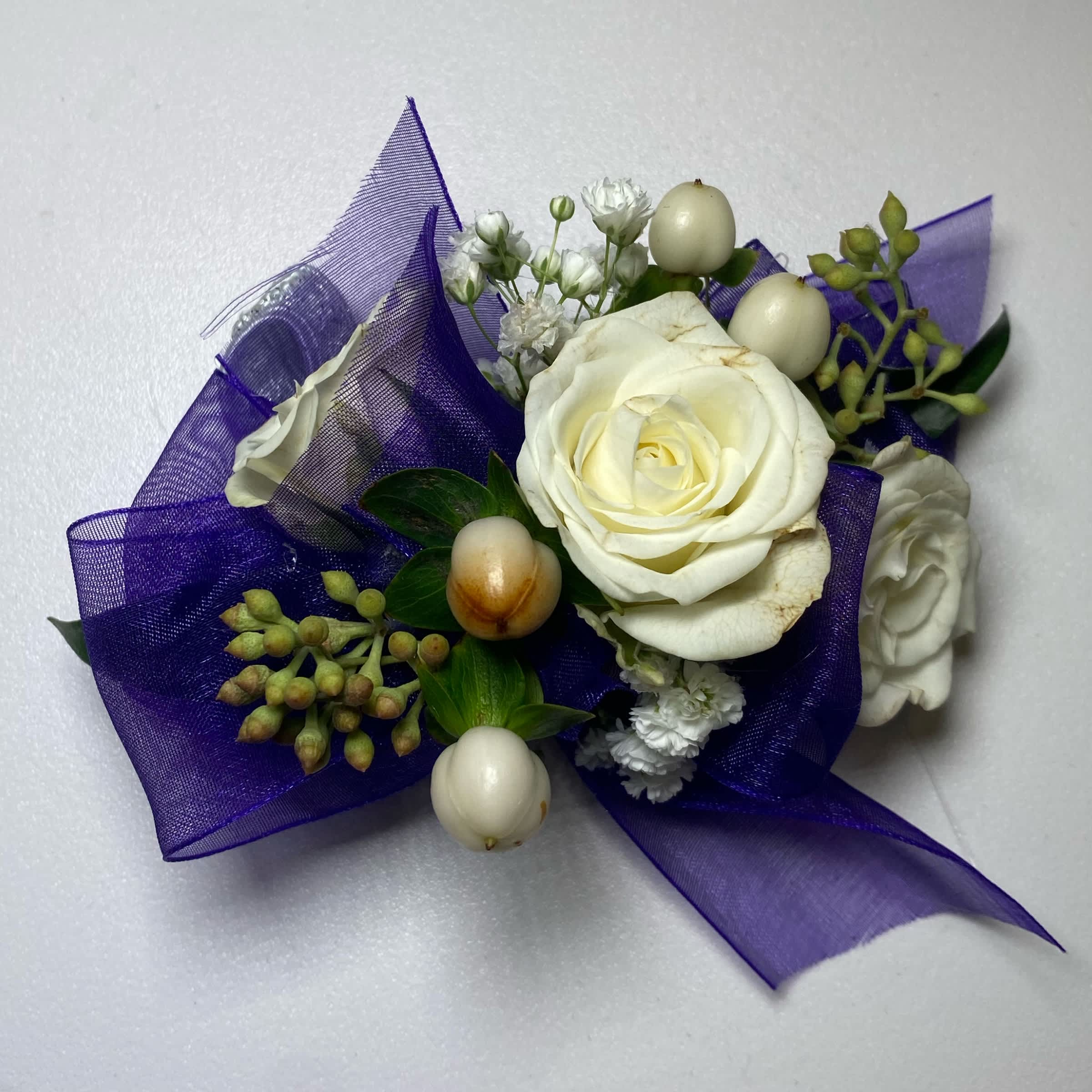 Purple/ White Rose Wrist Corsage - Prom/ Wedding - This White Rose Corsage Includes an Adult Size Elastic Wristband, Purple Chiffon Ribbon, White Spray Roses, Hypericum Berries, Gentle Greenery and Seeded Eucalyptus. Or as Similar as Possible.