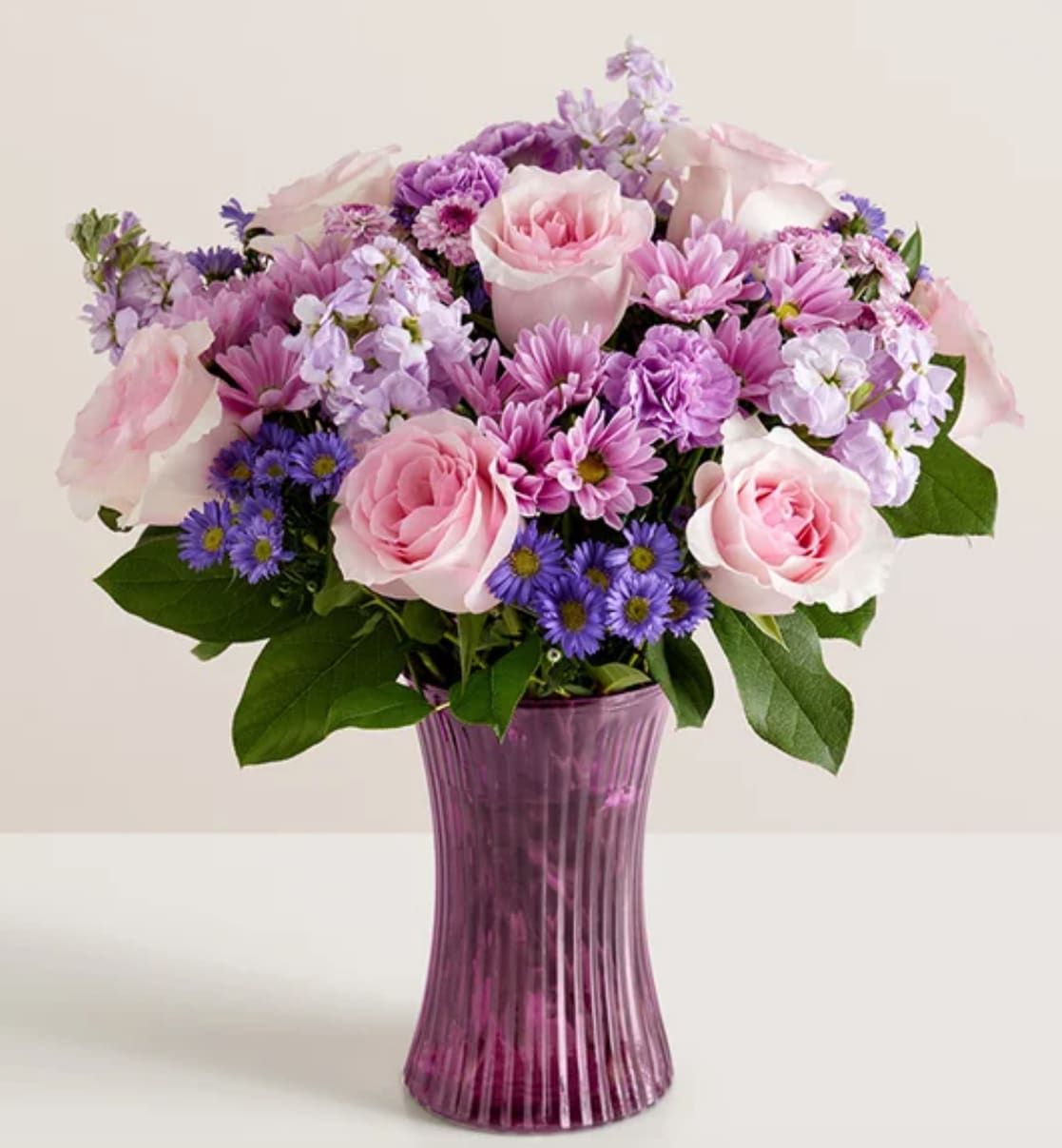 Daydream Bouquet™ V25 - Just like a daydream. Our delightful lavender bouquet is gathered with pops of pink and lush greenery inside our striking, new fluted violet gathering vase. Designed in vintage pressed glass with ribbed detailing, it captures the rich beauty of the blooms, along with the thoughtfulness of your sentiment.